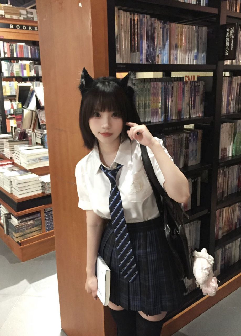 戴着猫的耳朵和领带的女孩为一张照片。