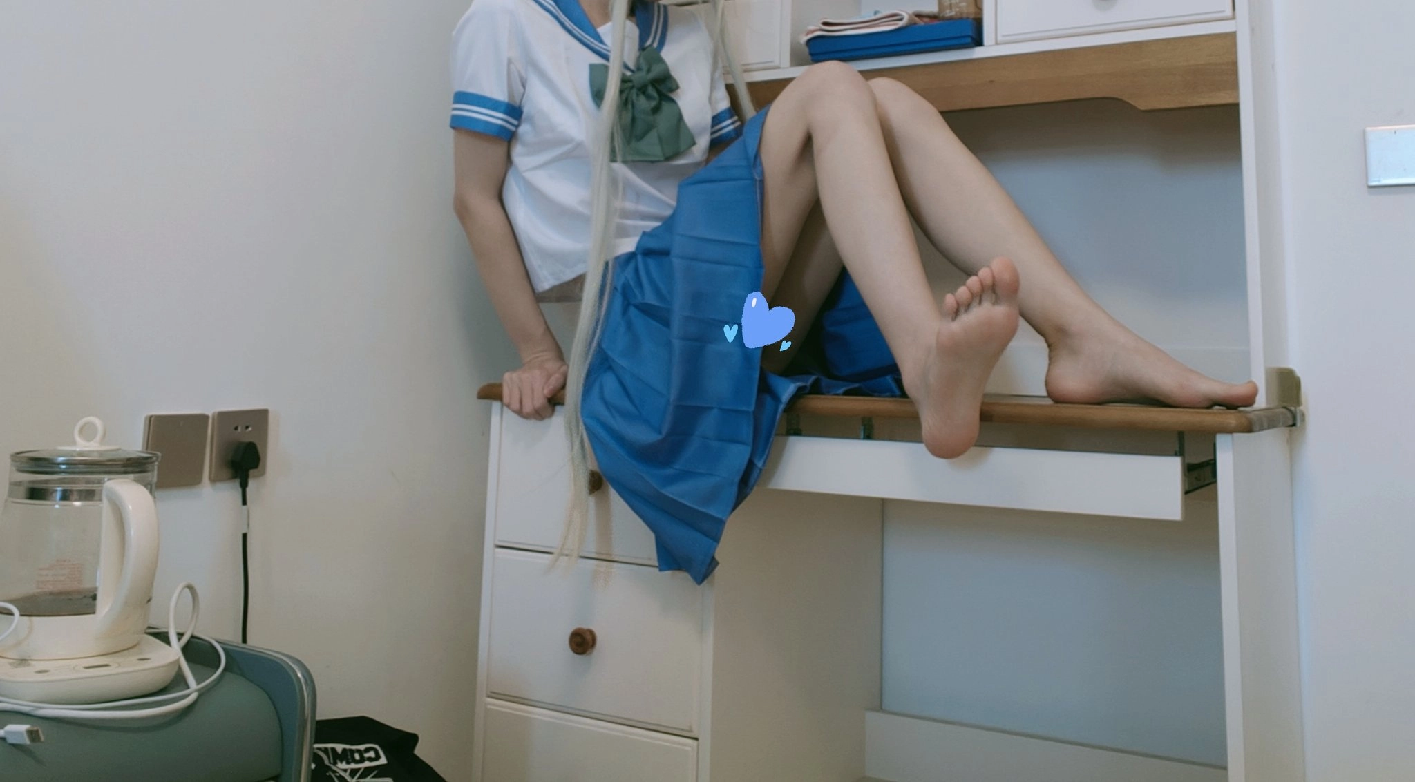 长头发的女孩和一个蓝色的弓坐在一个架子上。