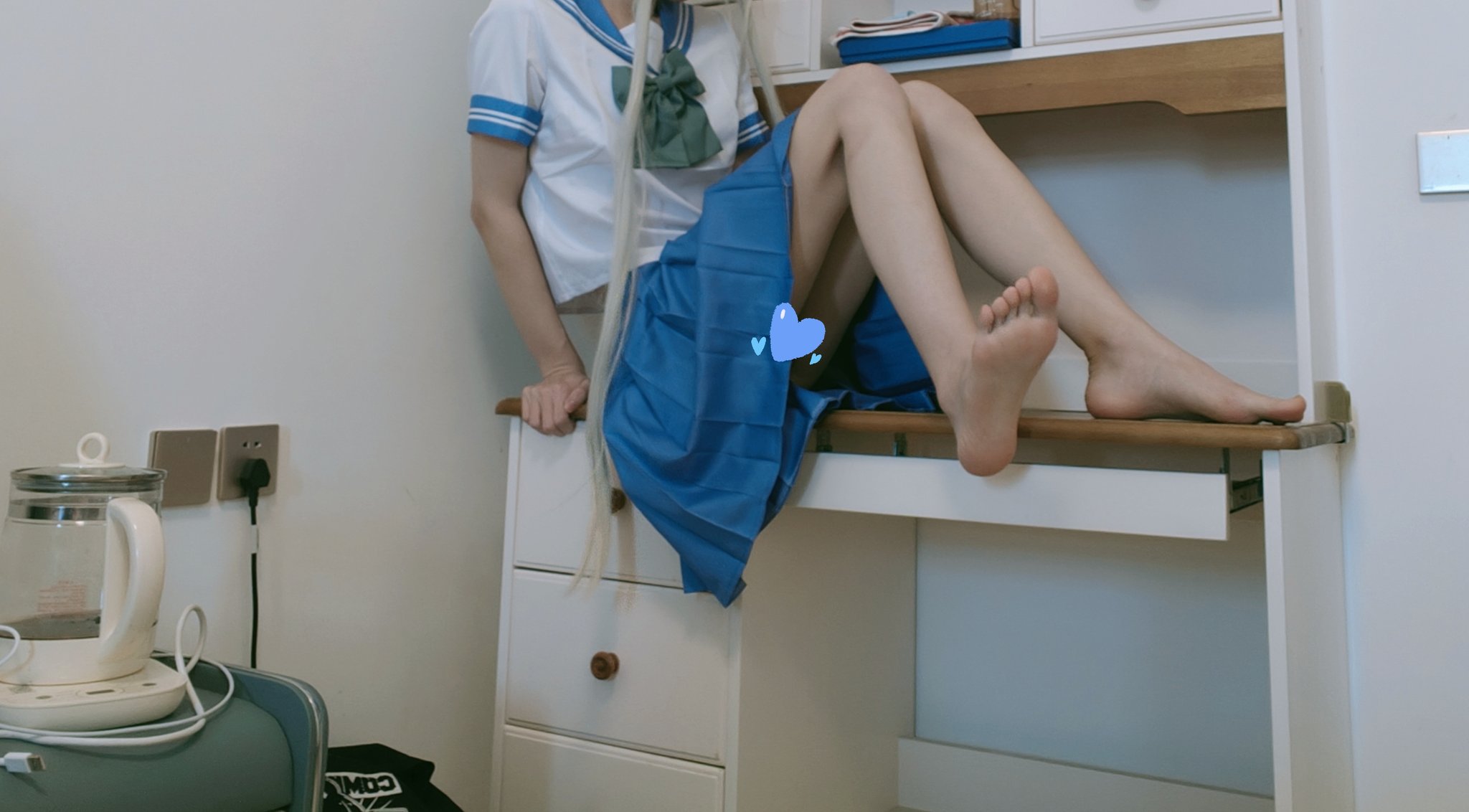 长头发的女孩和一个蓝色的弓坐在一个架子上。