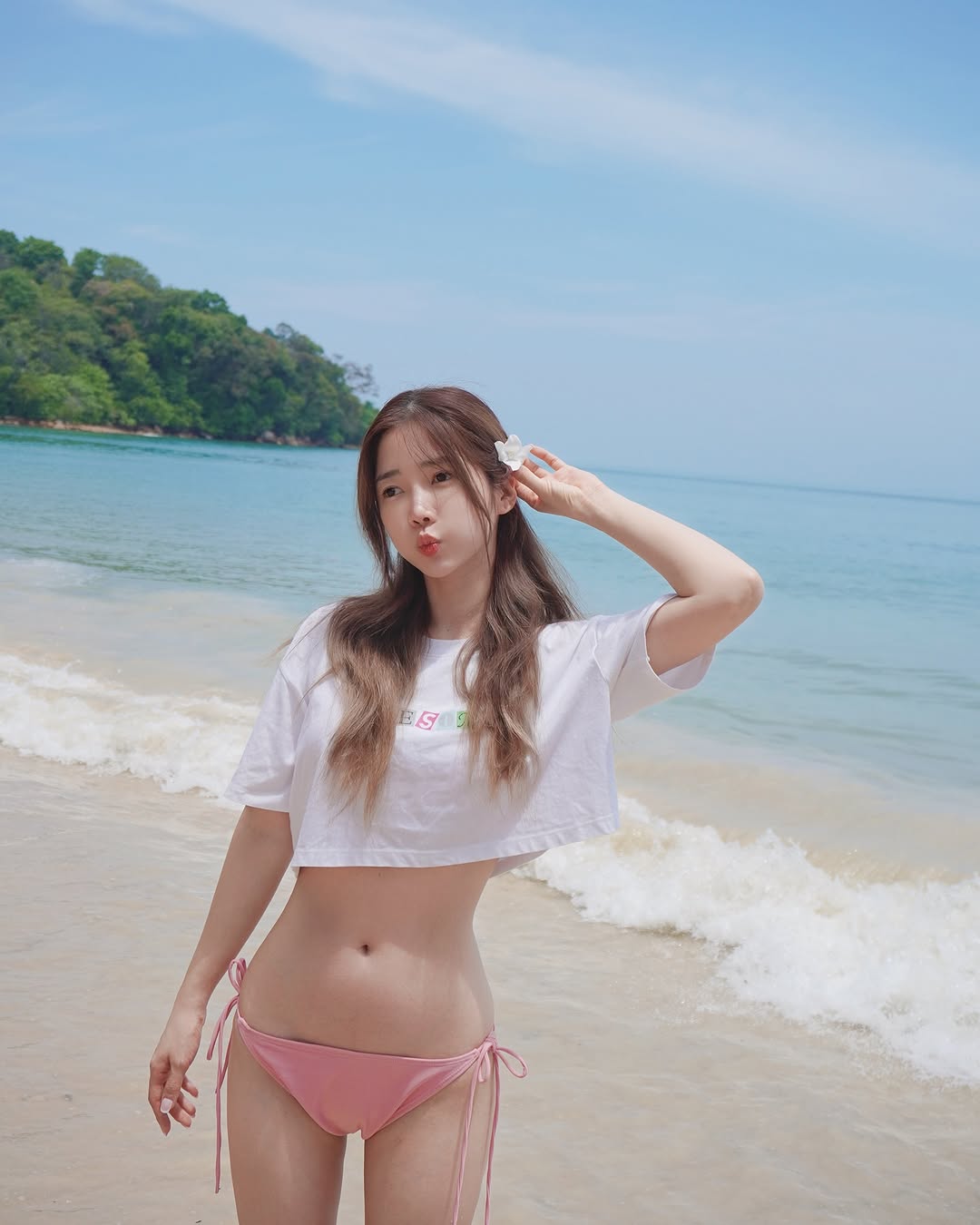 穿比基尼的女人坐在冲浪板上。