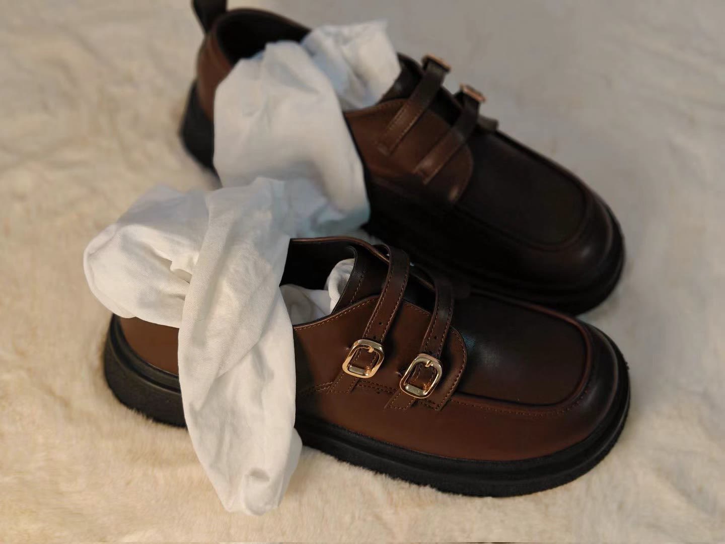 一双棕色鞋子,带有棕色带。