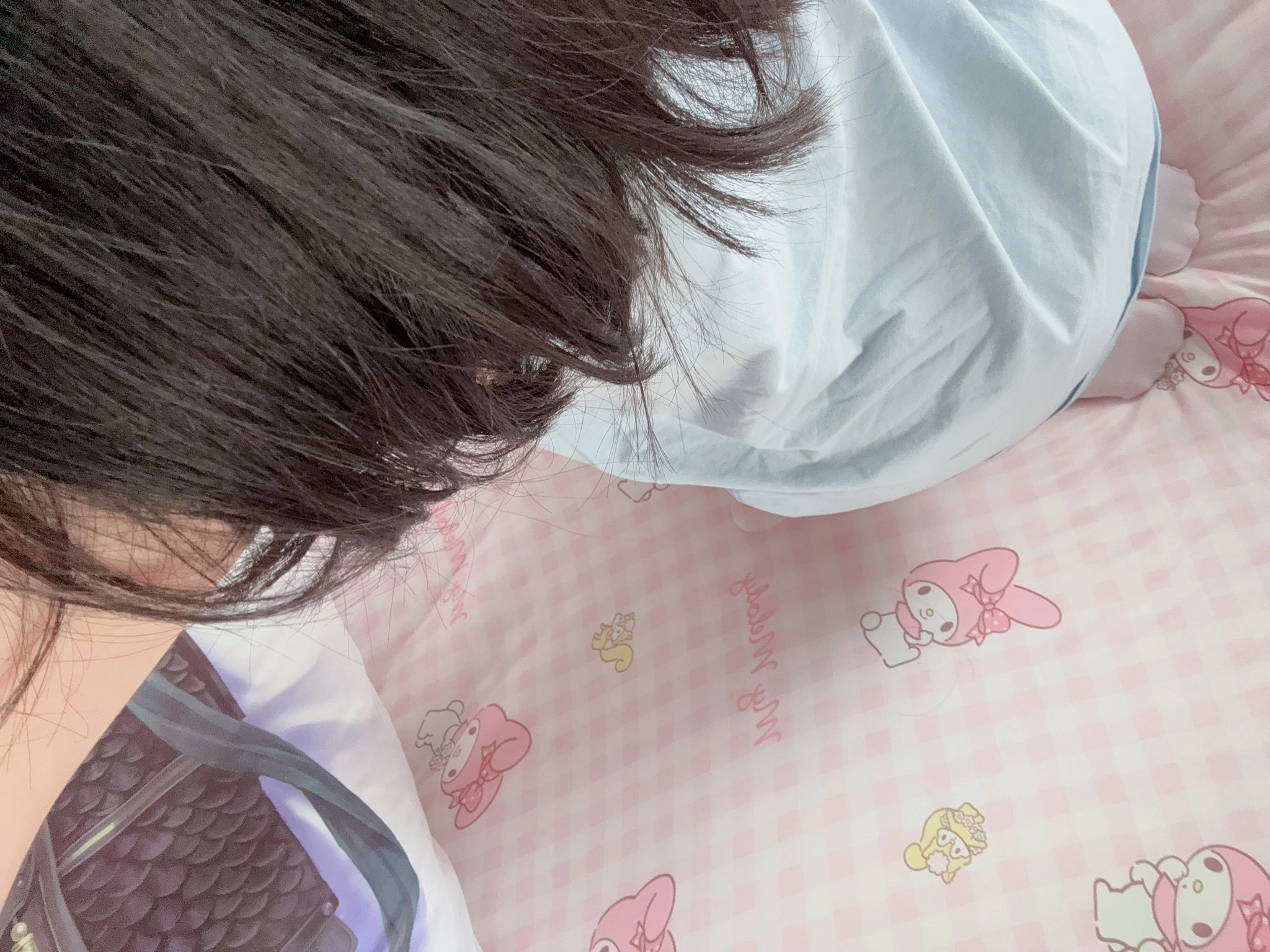 长头发的女孩看着一个粉红色和白色的毯子。