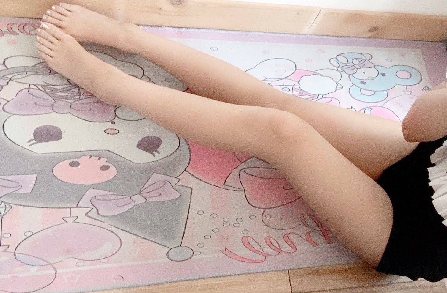 女人躺在一个粉红色的地毯上,有一个Hello Kitty设计。