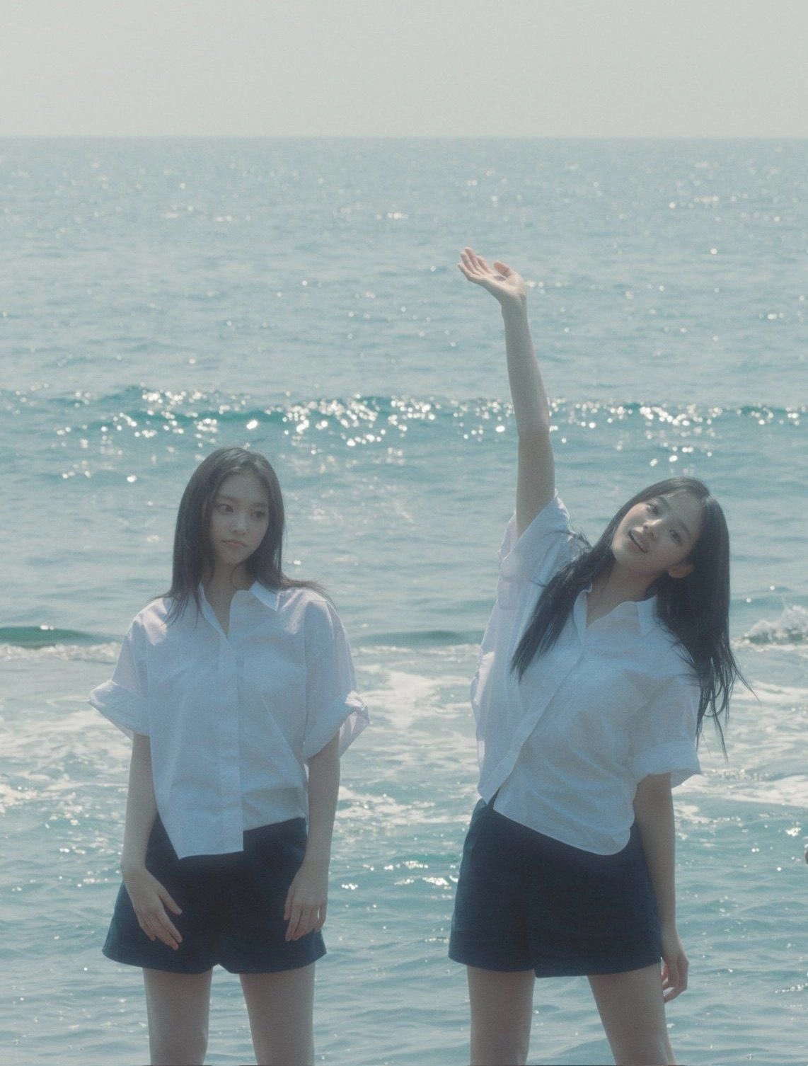 两个女孩站在海滩上。