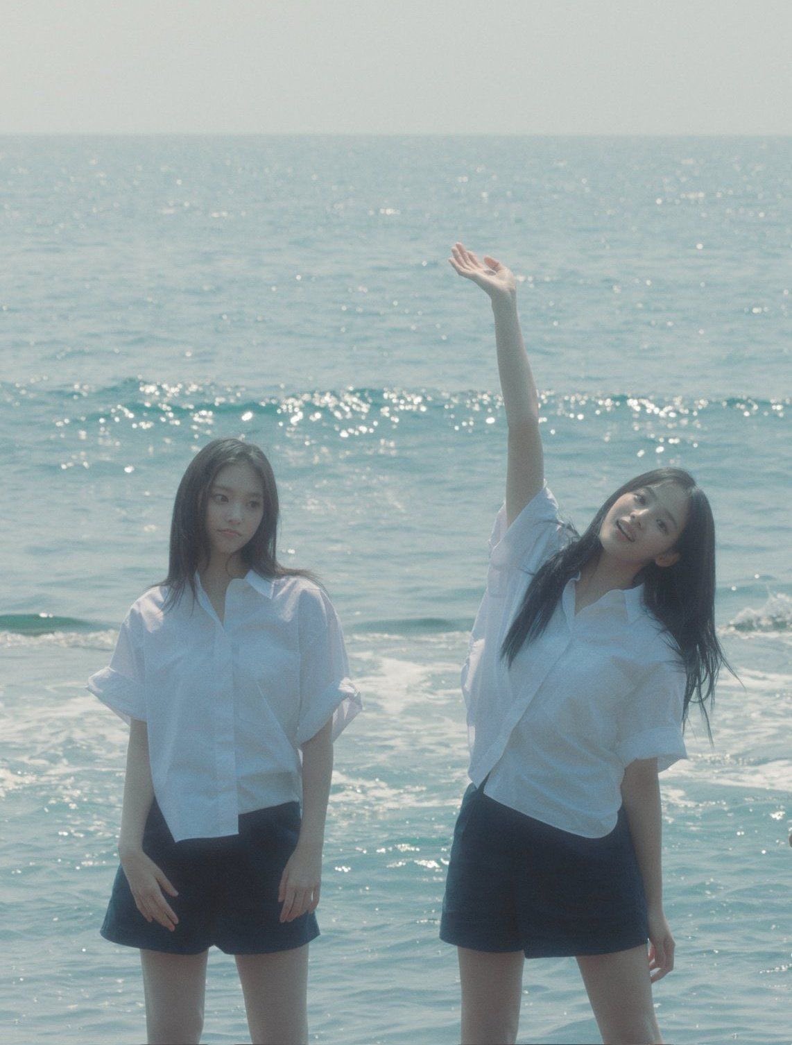 两个女孩站在海滩上。