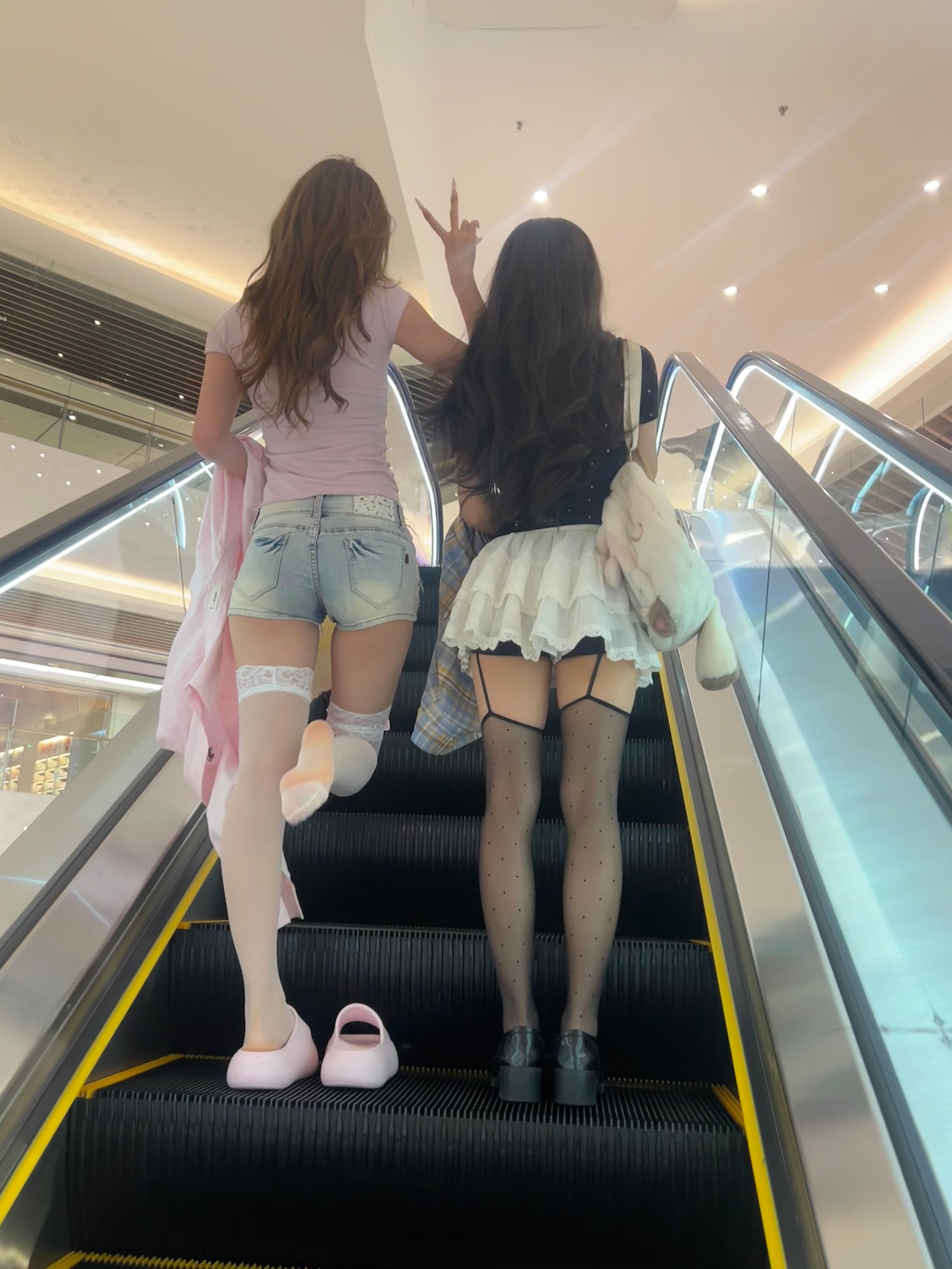 两个穿短裤和高跟鞋的女人正在爬上楼梯。