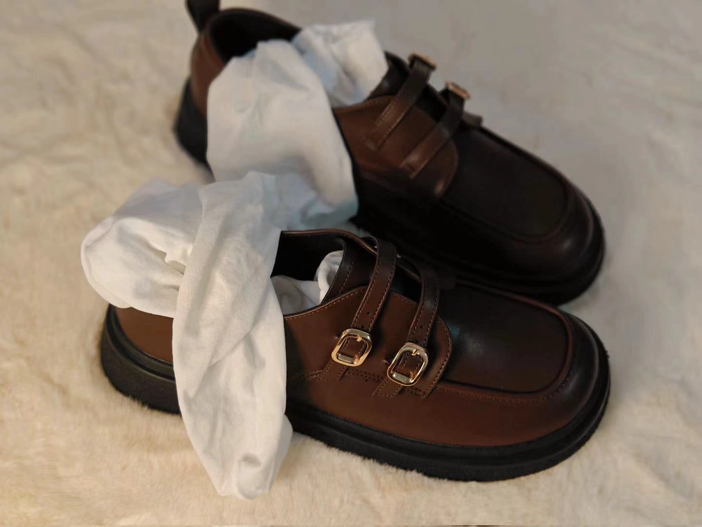 一双棕色鞋子,带有棕色带。