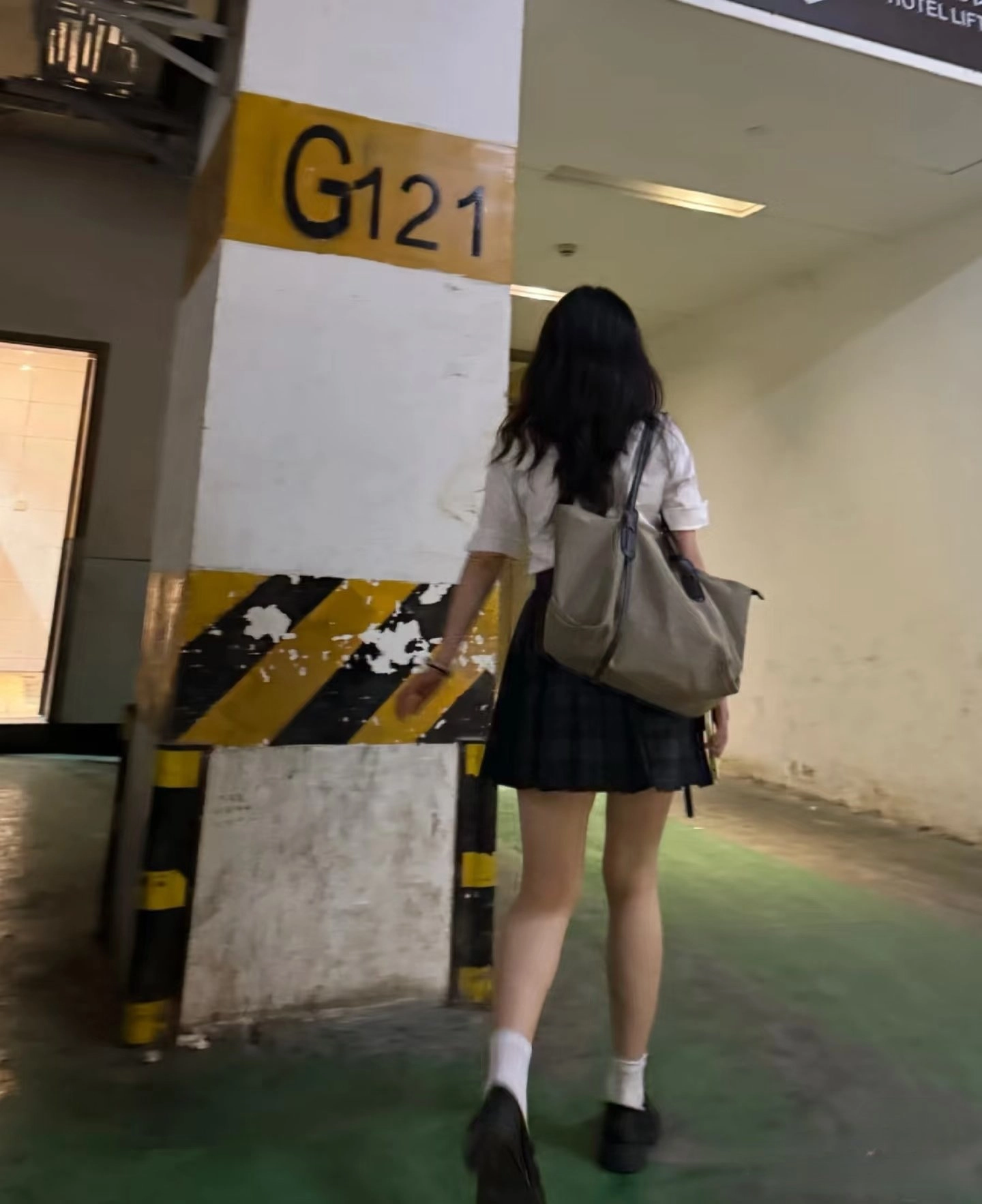 女人走过一个黄色标志,上面有121号。