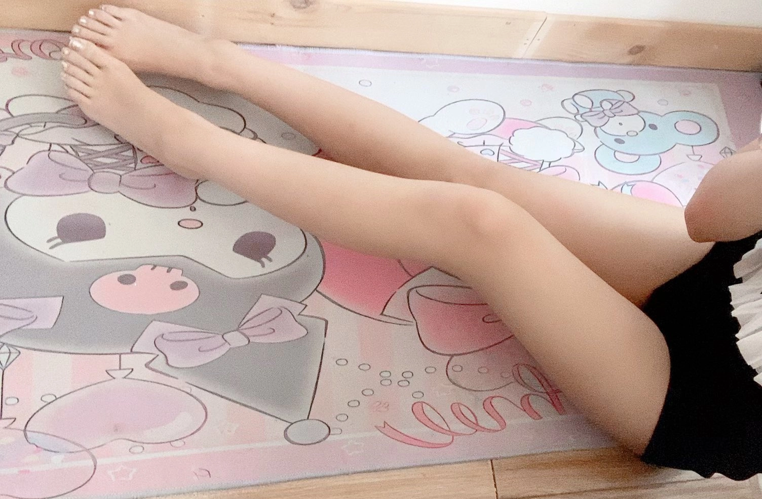 女人躺在一个粉红色的地毯上,有一个Hello Kitty设计。