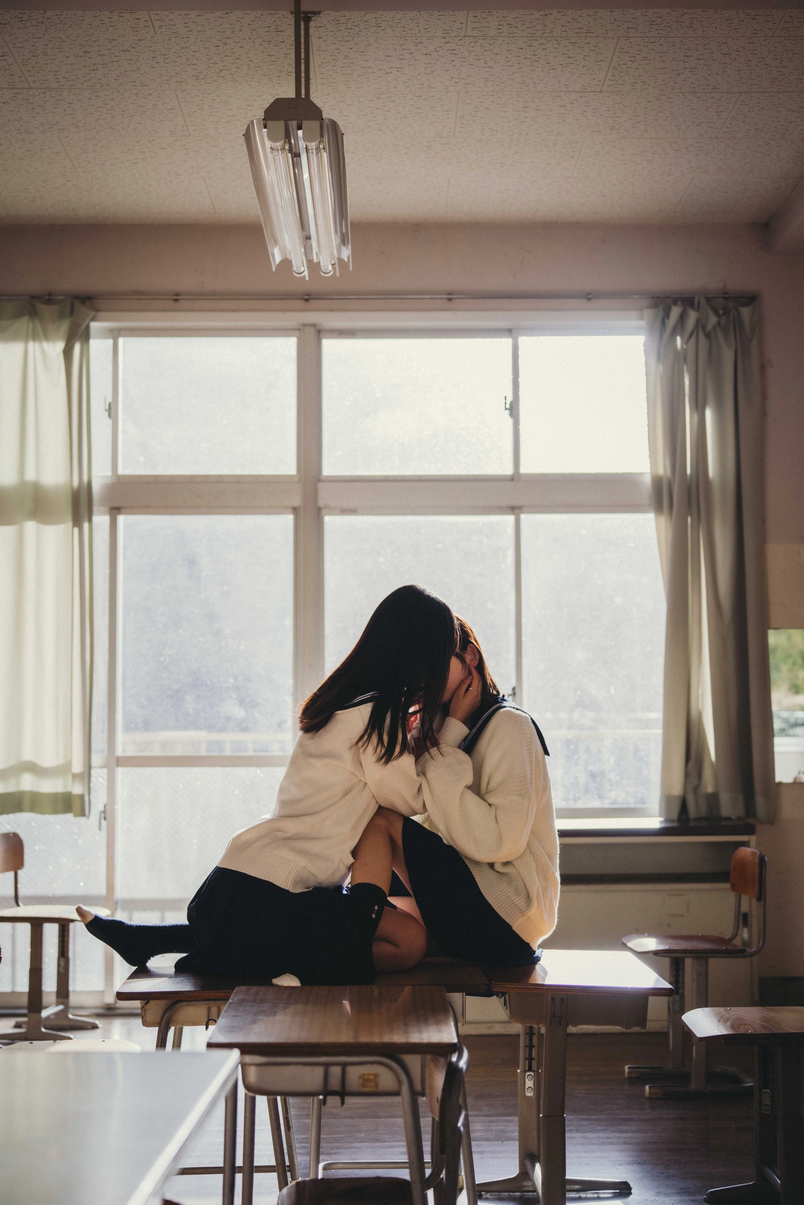 两个女孩在教室里接吻。