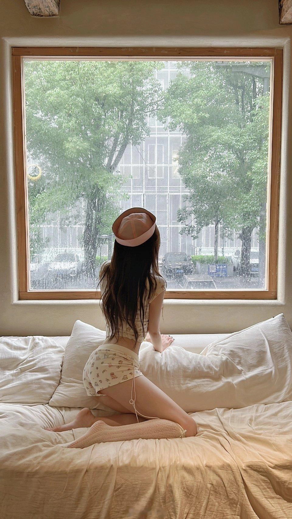 穿着粉红色的帽子的女人坐在床上。