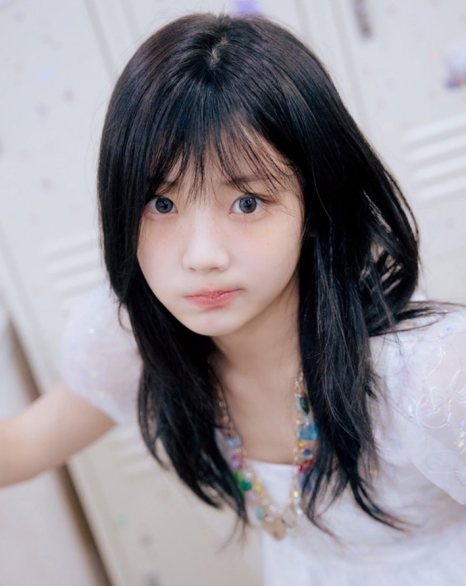 一位穿着白色裙子和靴子的女人拿着手机。