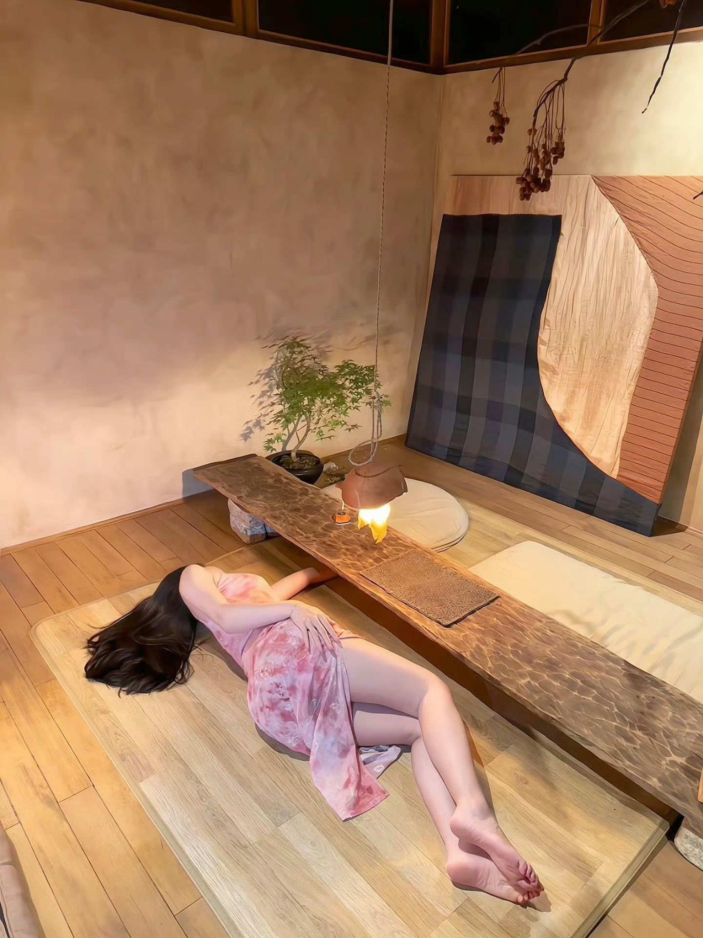 穿红色衣服的女人躺在一张木凳上。