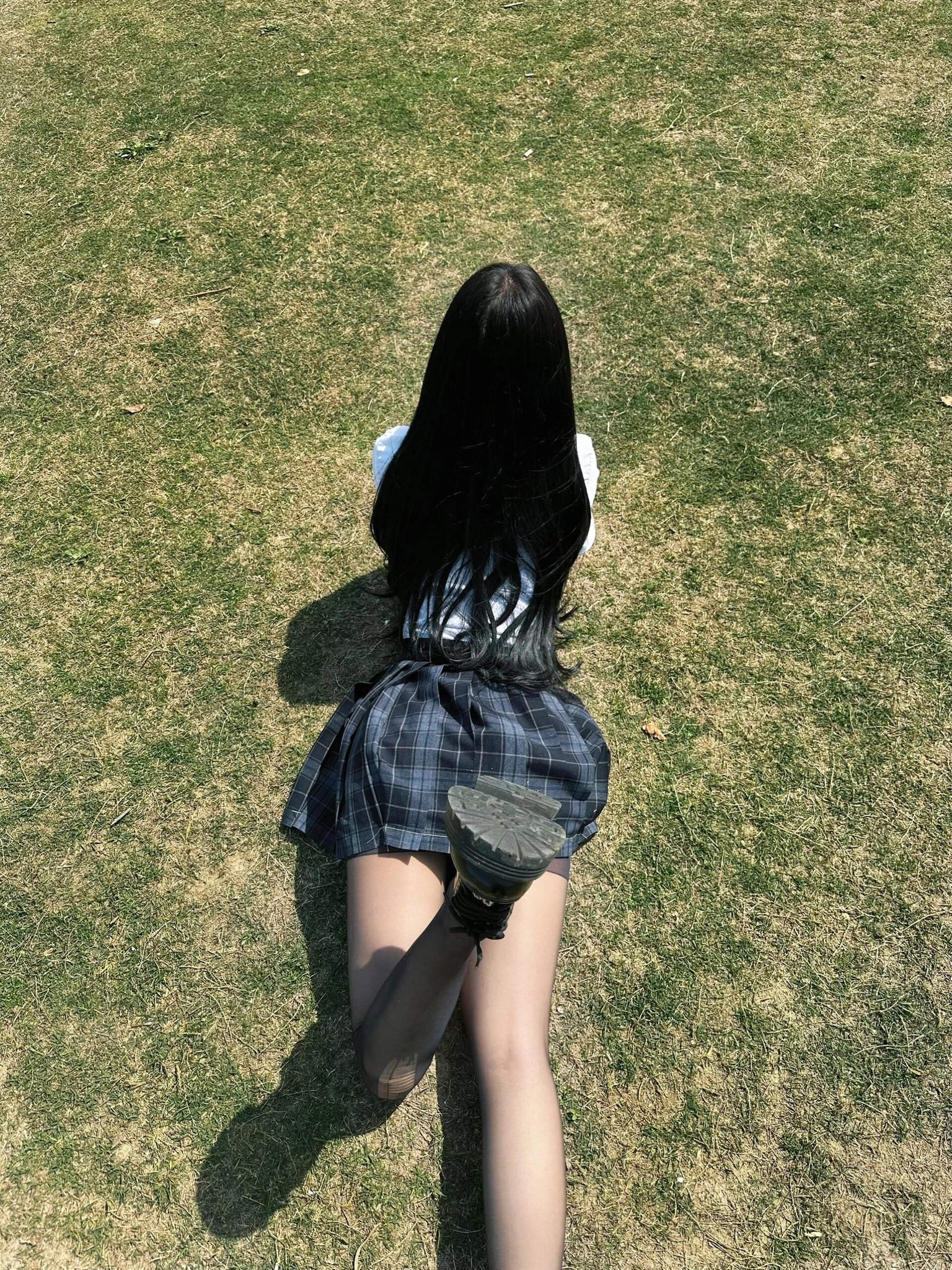 长头发的女人坐在草地上。