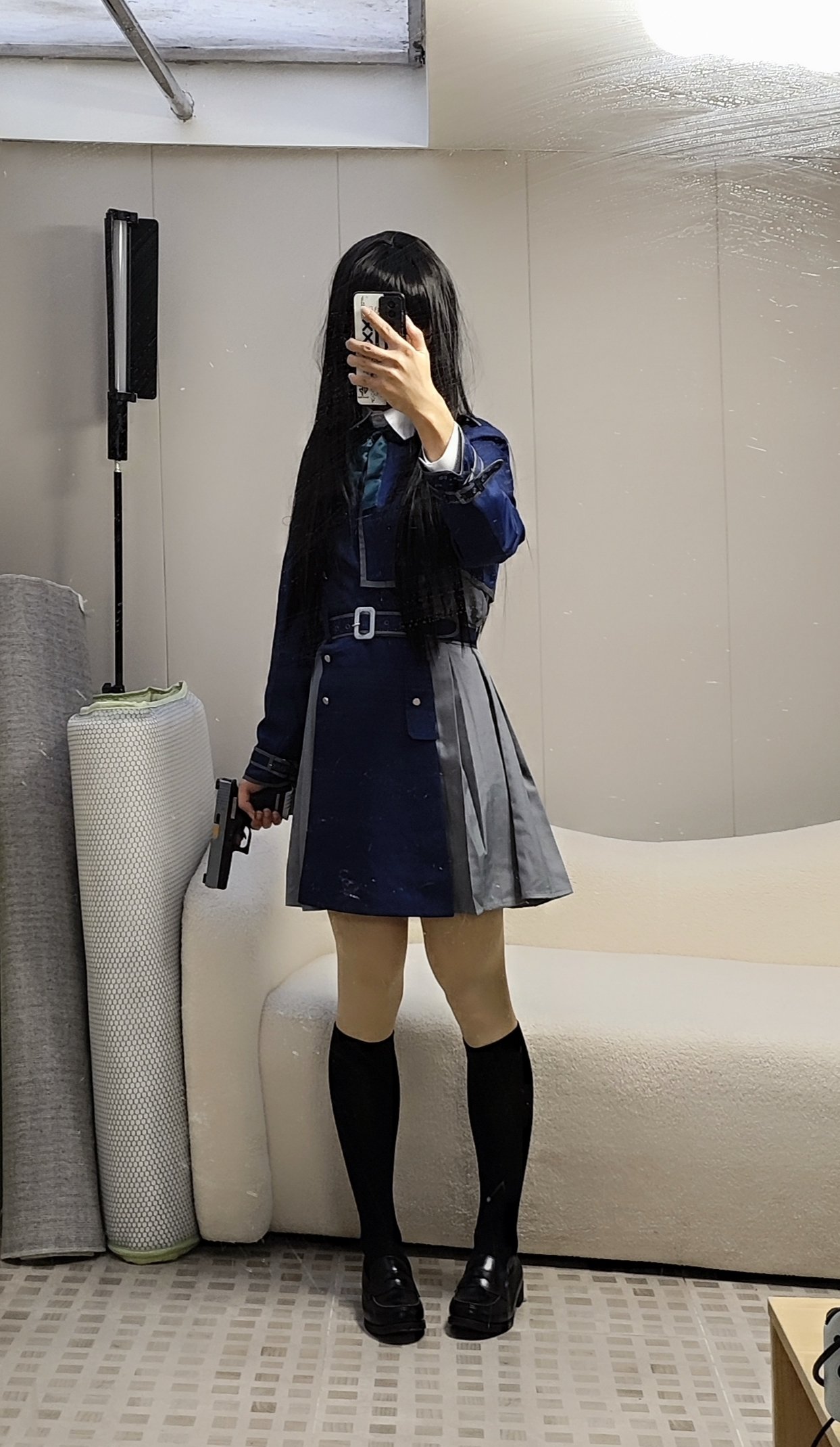 一位穿着蓝色裙子和黑色袜子的女人在镜子前拿着一把枪。