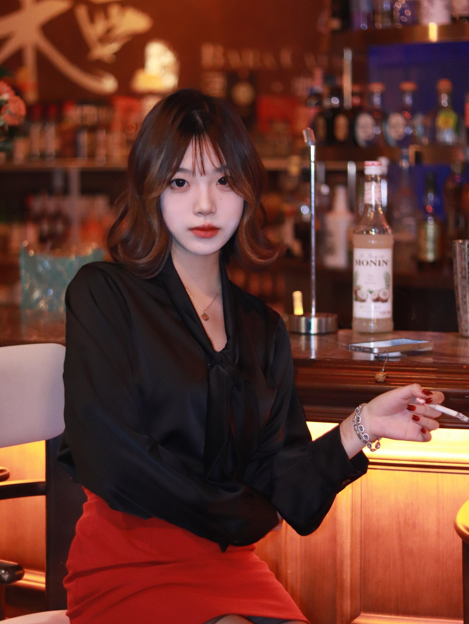 红头发和黑衬衫的女人抽了一支烟。