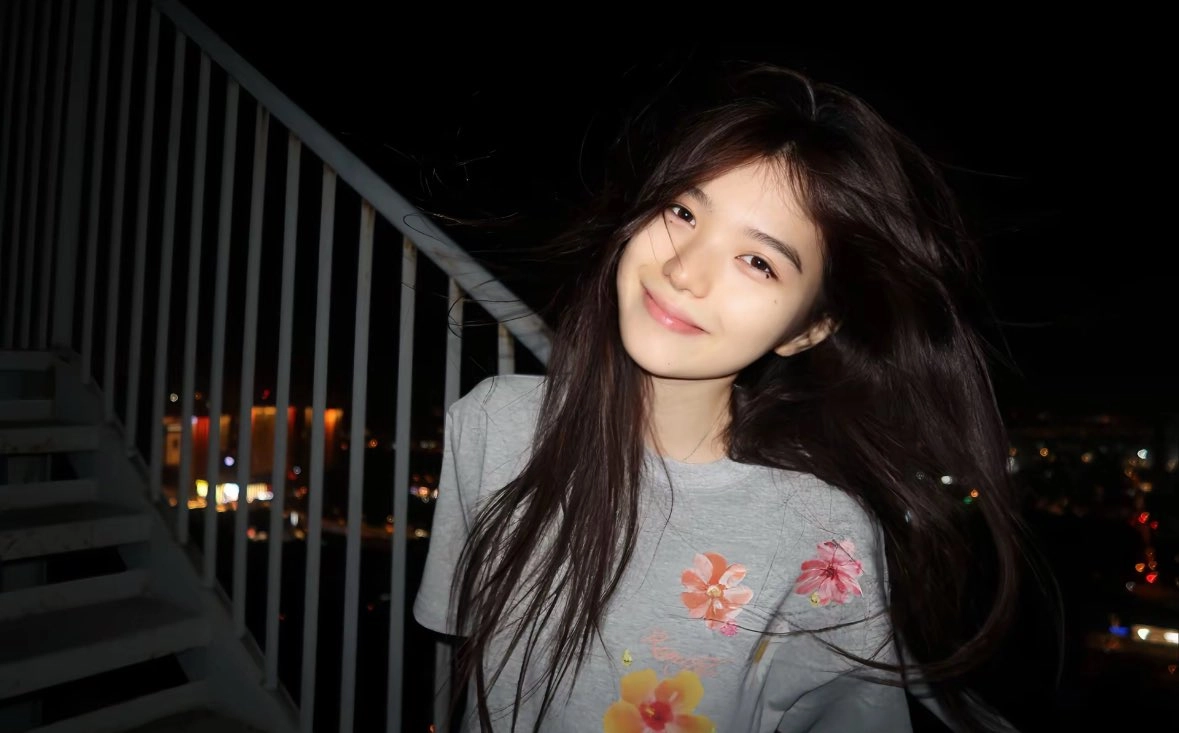 长头发和灰色衬衫的女人微笑。