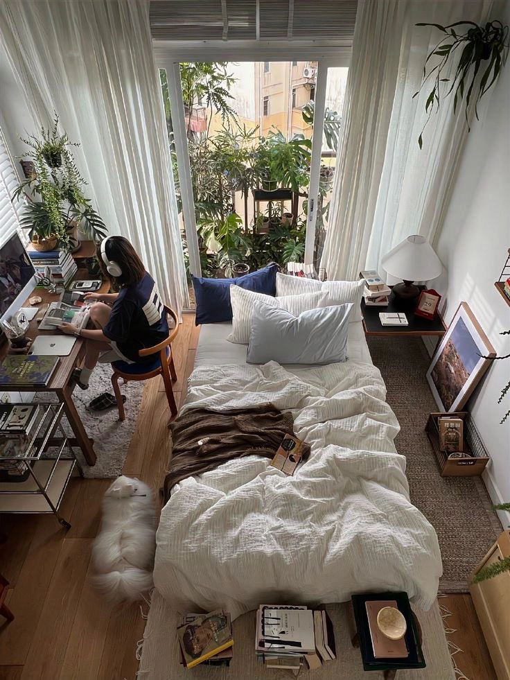 女人坐在椅子上,和一只狗在床前。