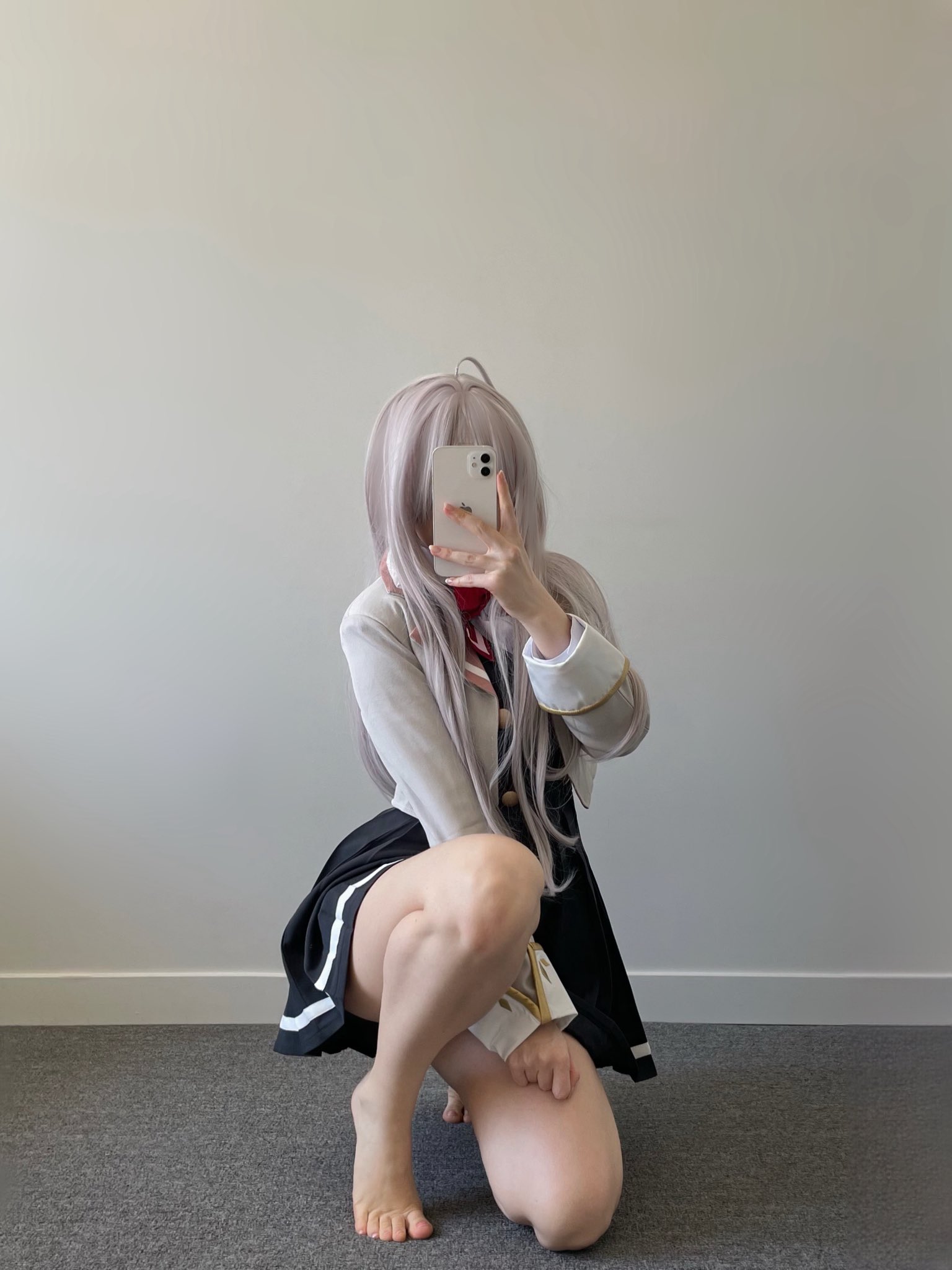 女人在一个白色的墙前拍自拍。