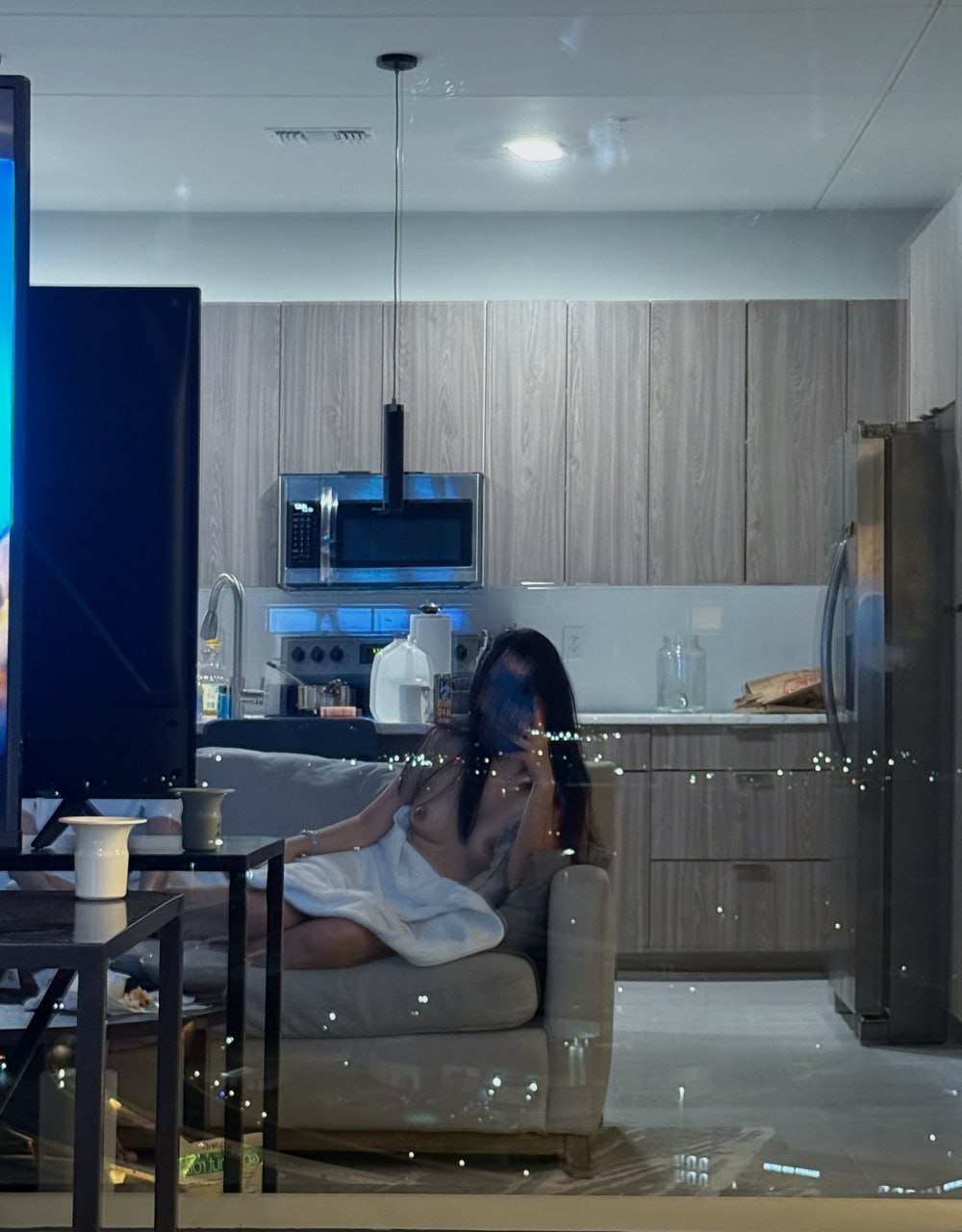 女人坐在客厅的沙发上。