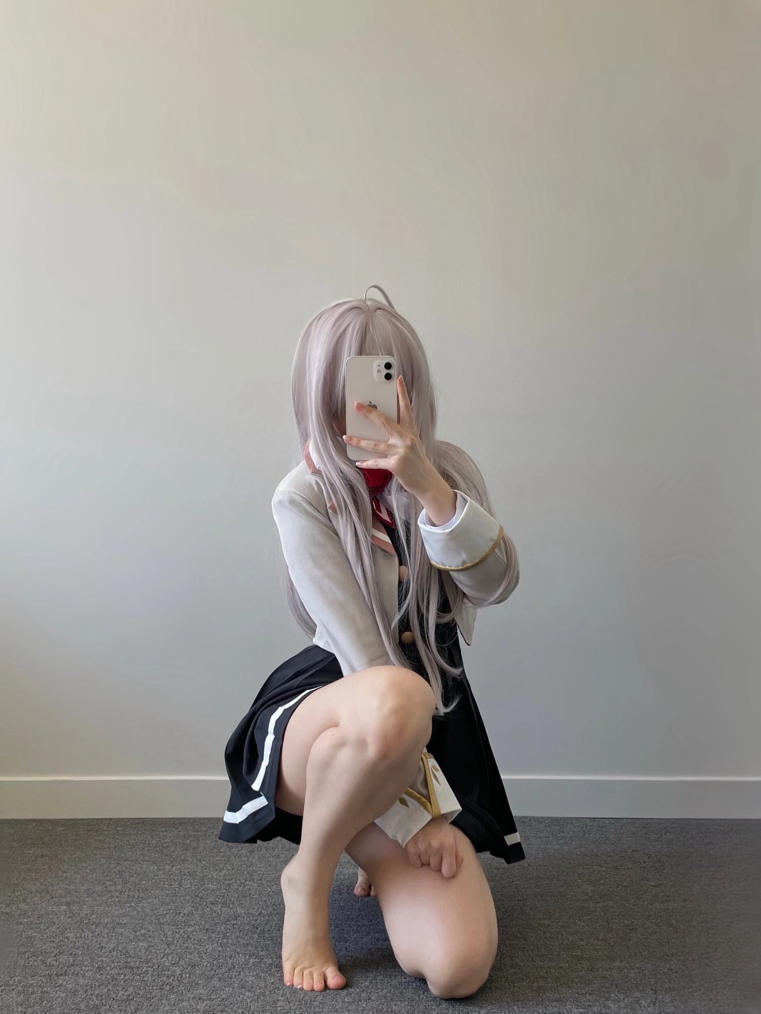 女人在一个白色的墙前拍自拍。