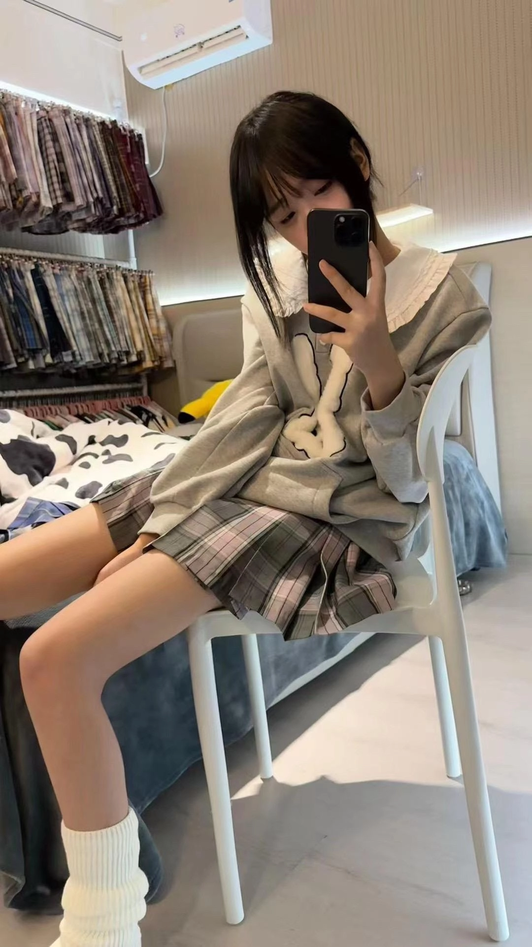 穿着灰色衬衫的女人拿着手机。