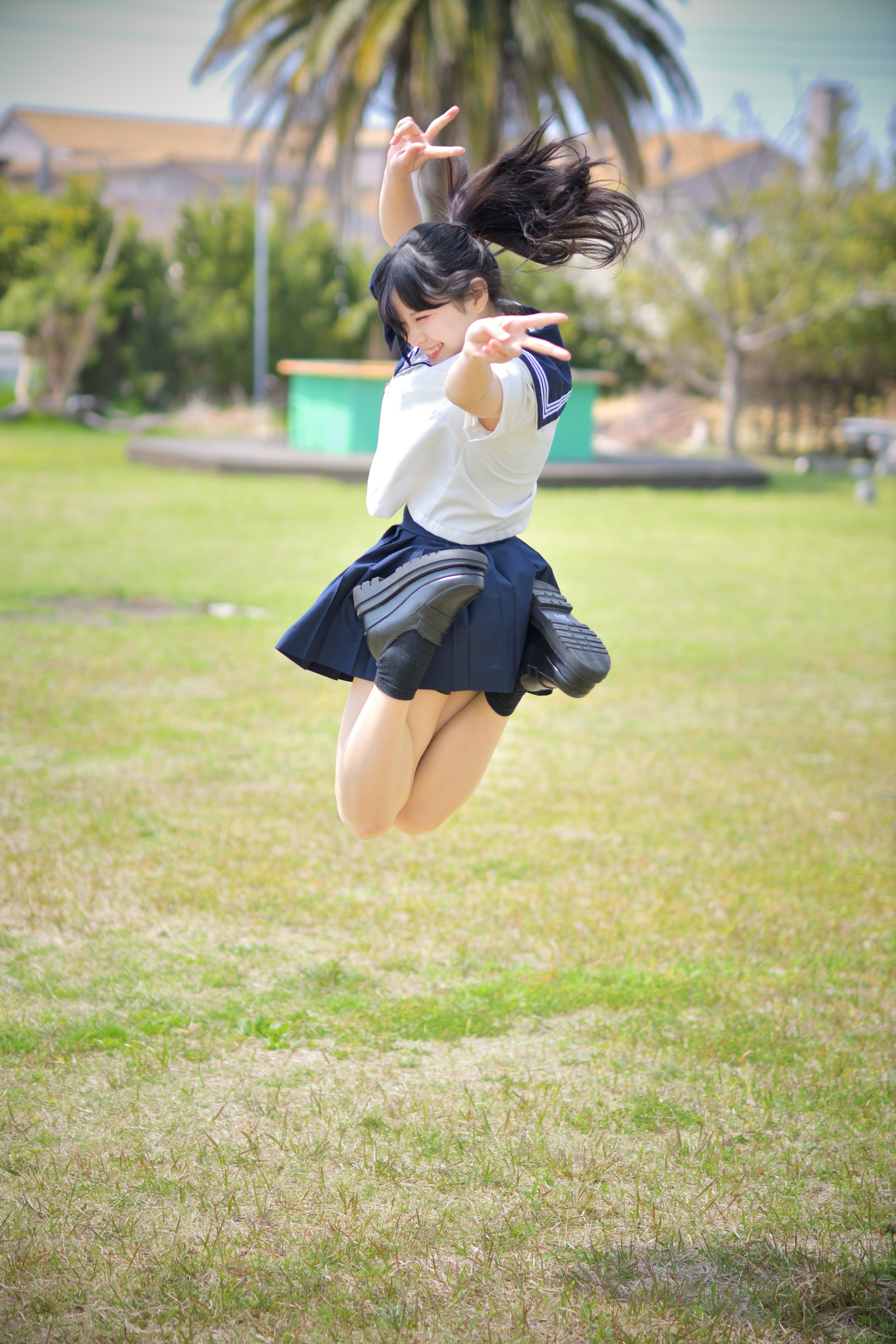 穿着白色衬衫和黑色裙子的女孩正在跳进空中。