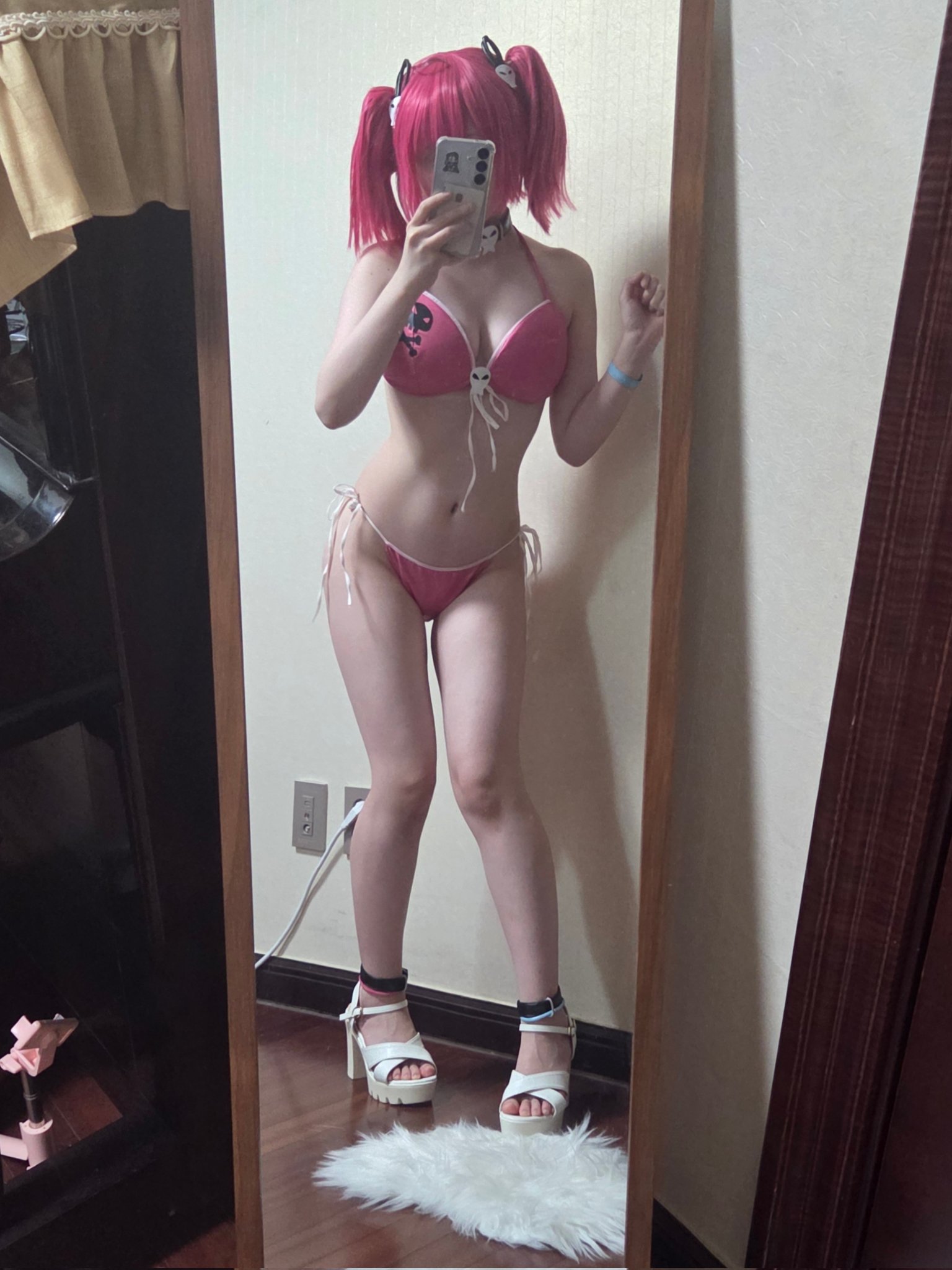 穿着粉红色比基尼的女人在镜子前拍个自拍。
