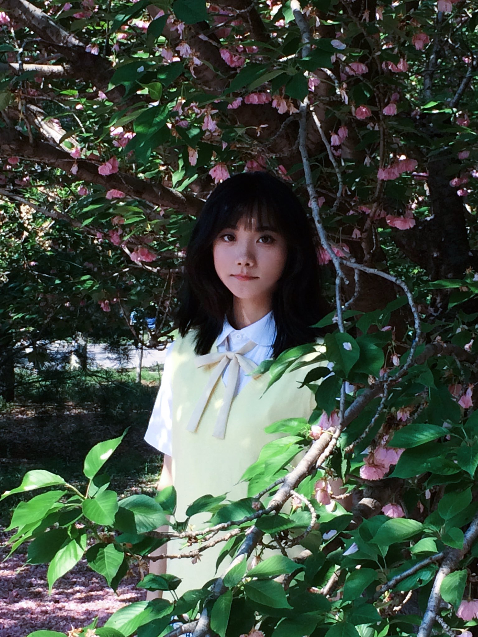 头发上有弓的女人站在一棵树前。