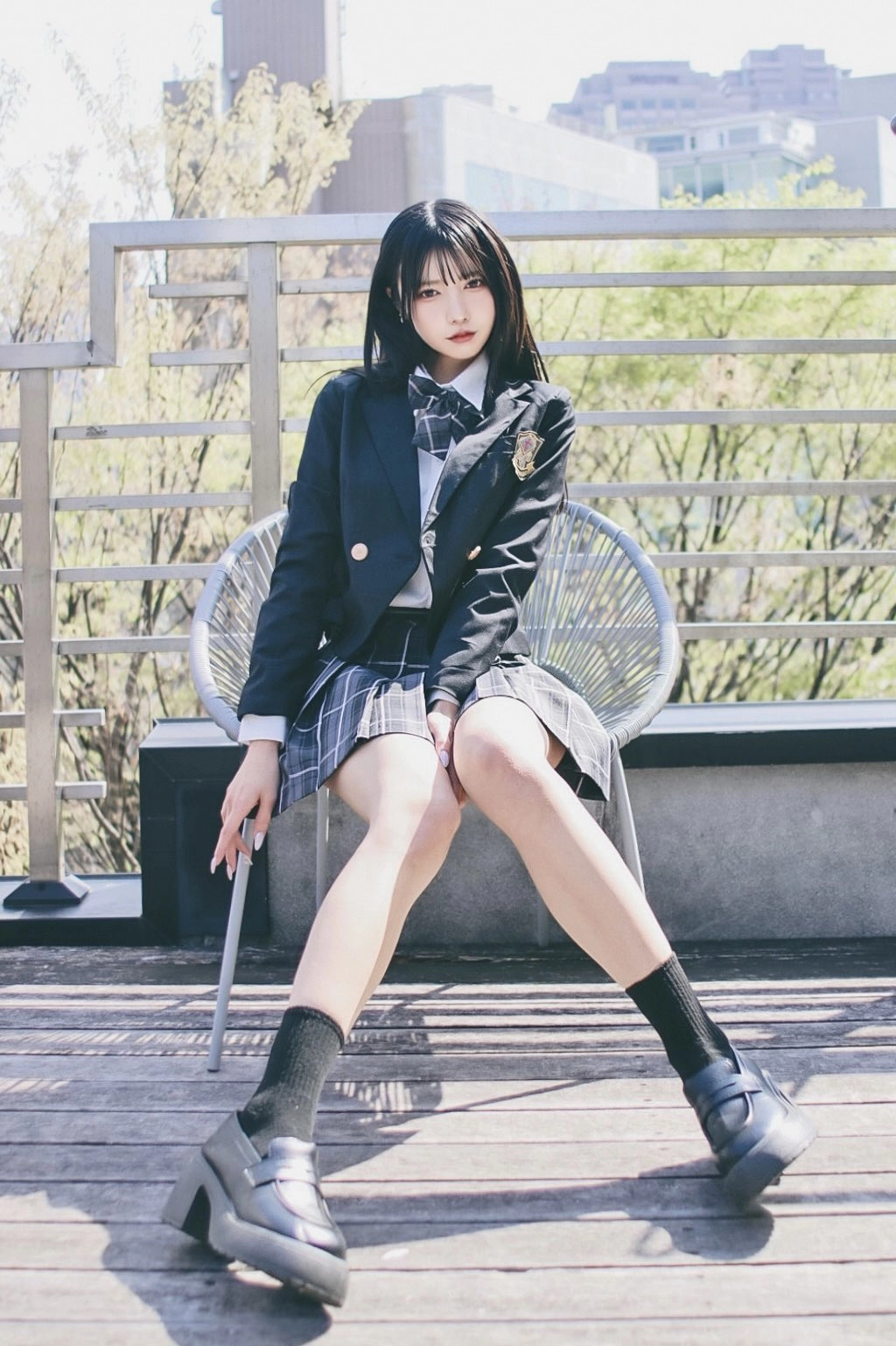 穿着黑色服装和领带的女人坐在一个凳子上。