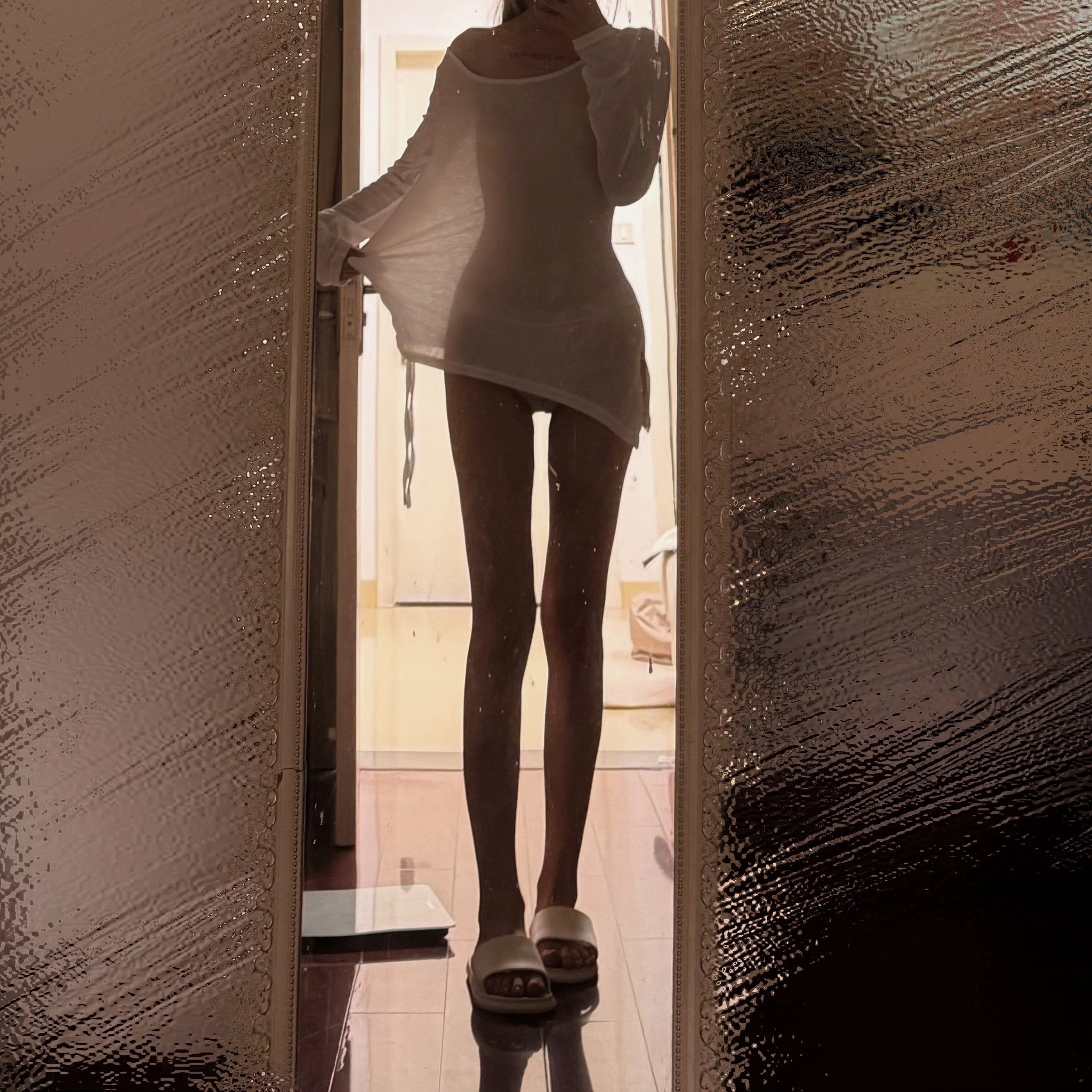 穿着白色衣服的女人站在门口。