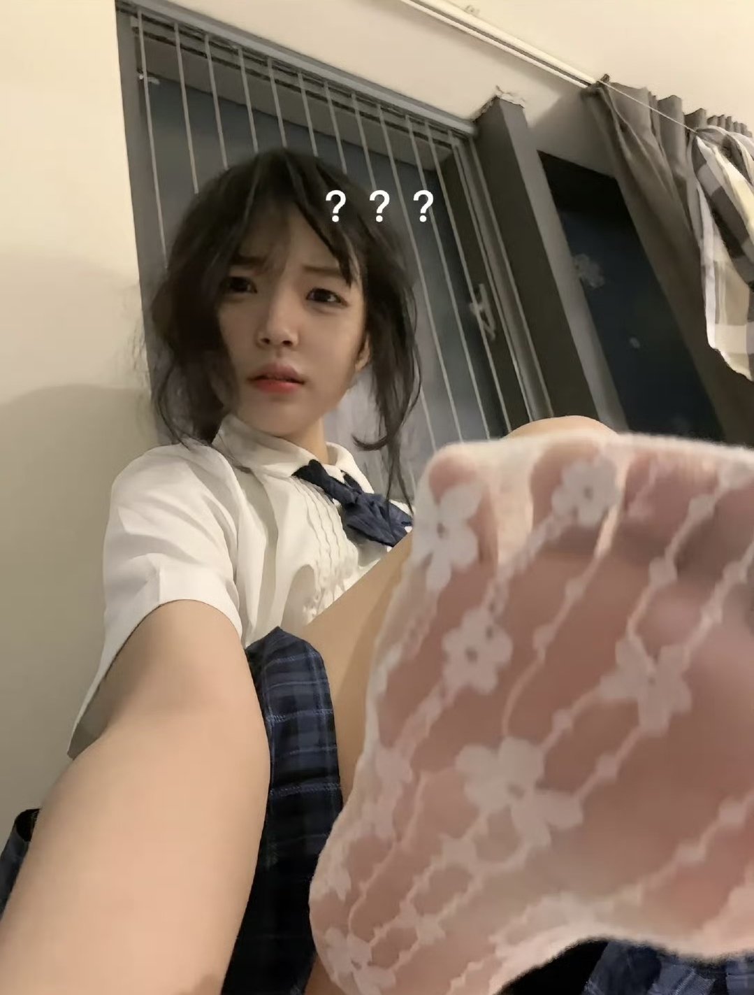 头发上有蓝弓的女人坐在地板上。