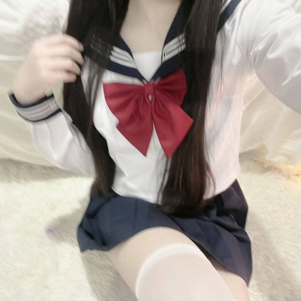 穿着水手服的女孩和一个红色的弓。