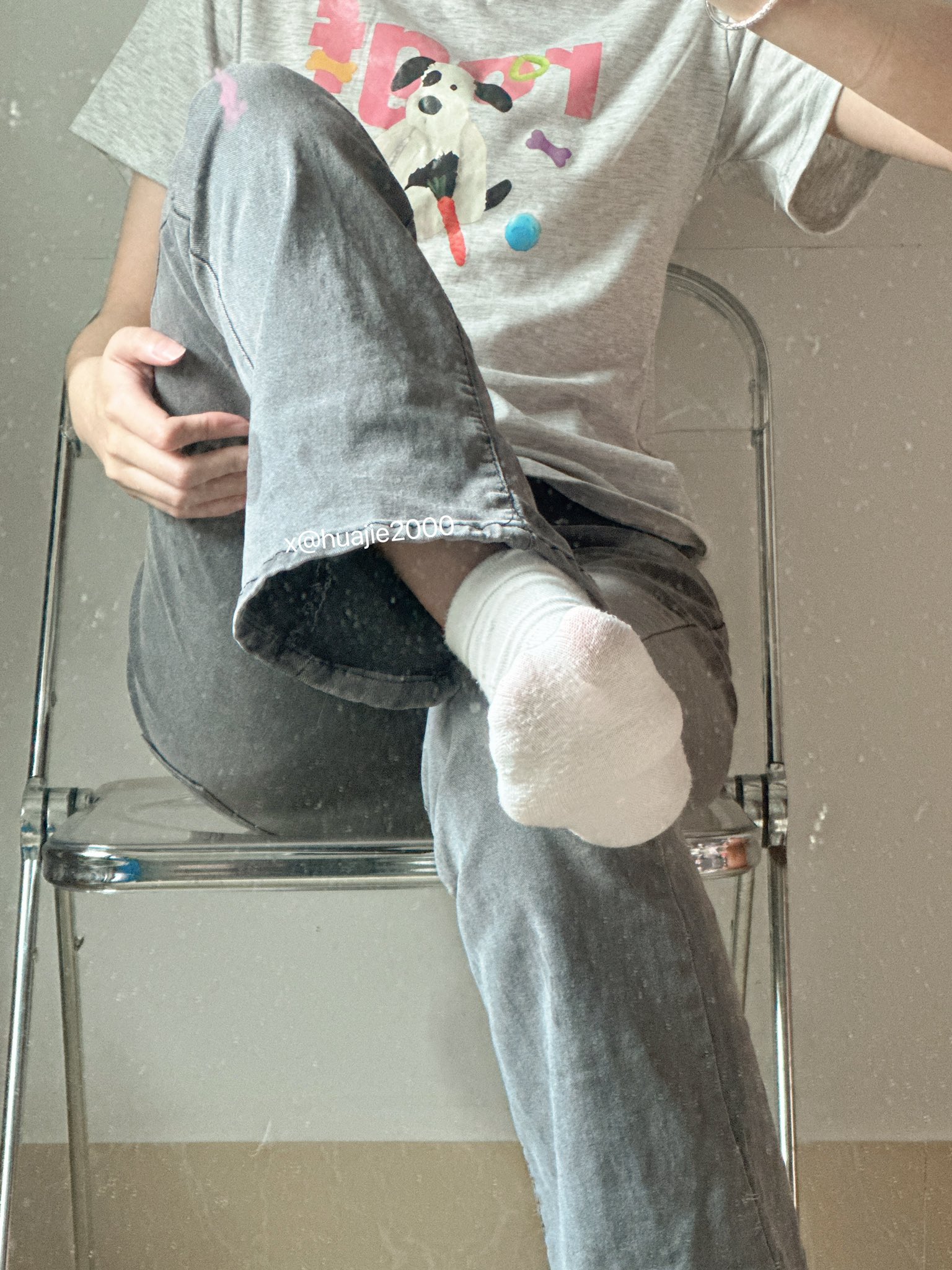 穿着灰色衬衫和白色袜子的人坐在椅子上。