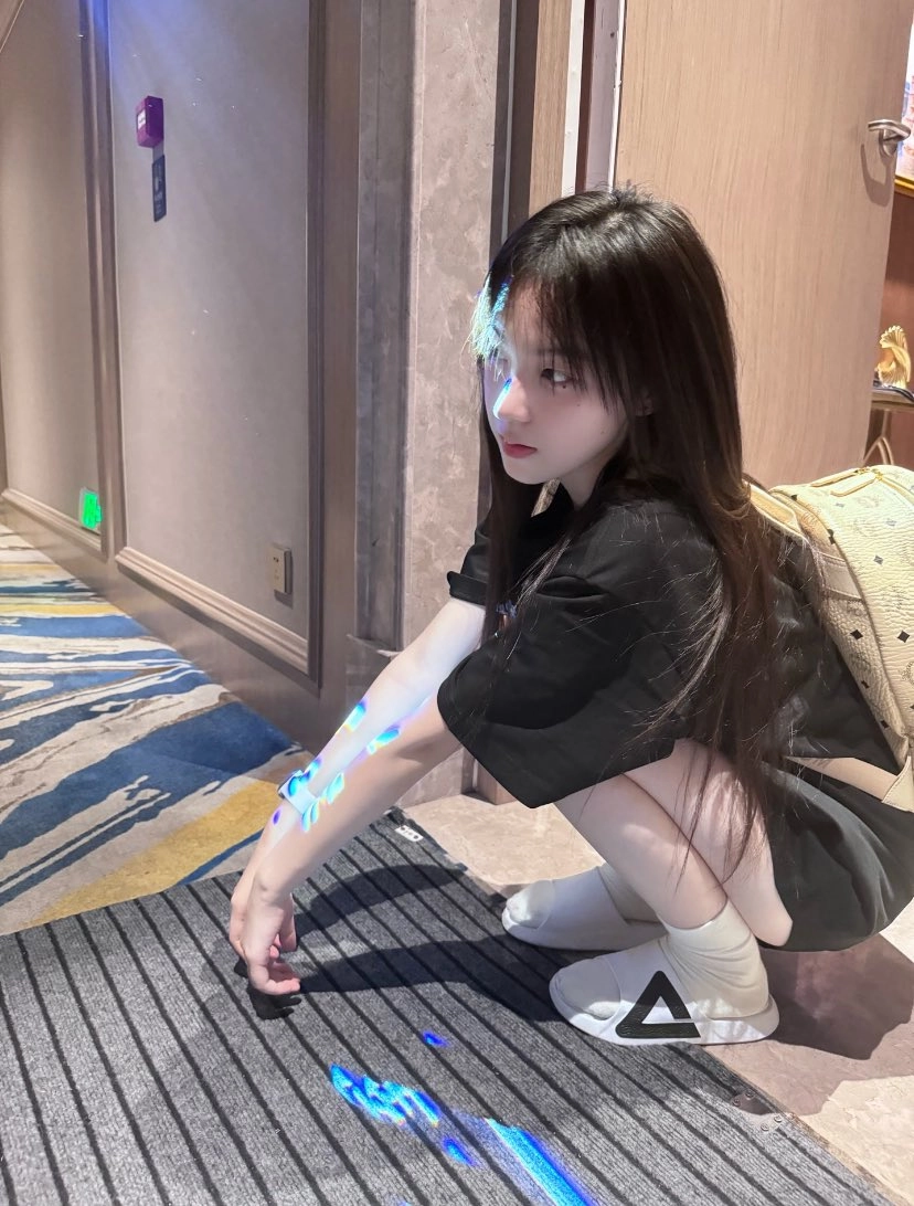 带着背包的女人跪下,看着她的手。