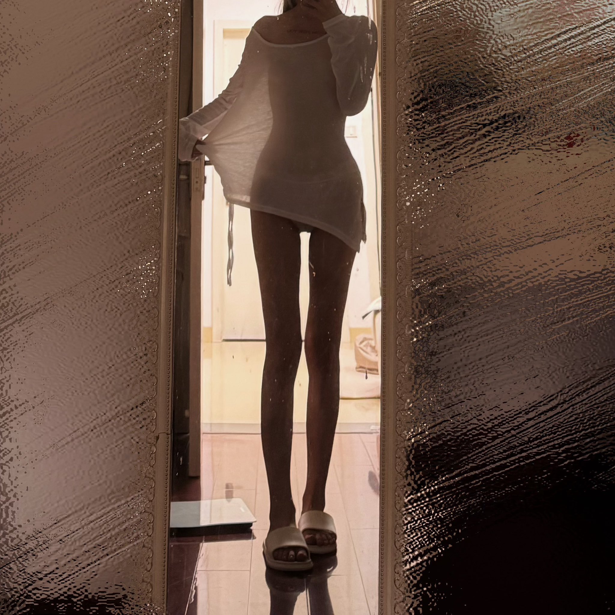 穿着白色衣服的女人站在门口。