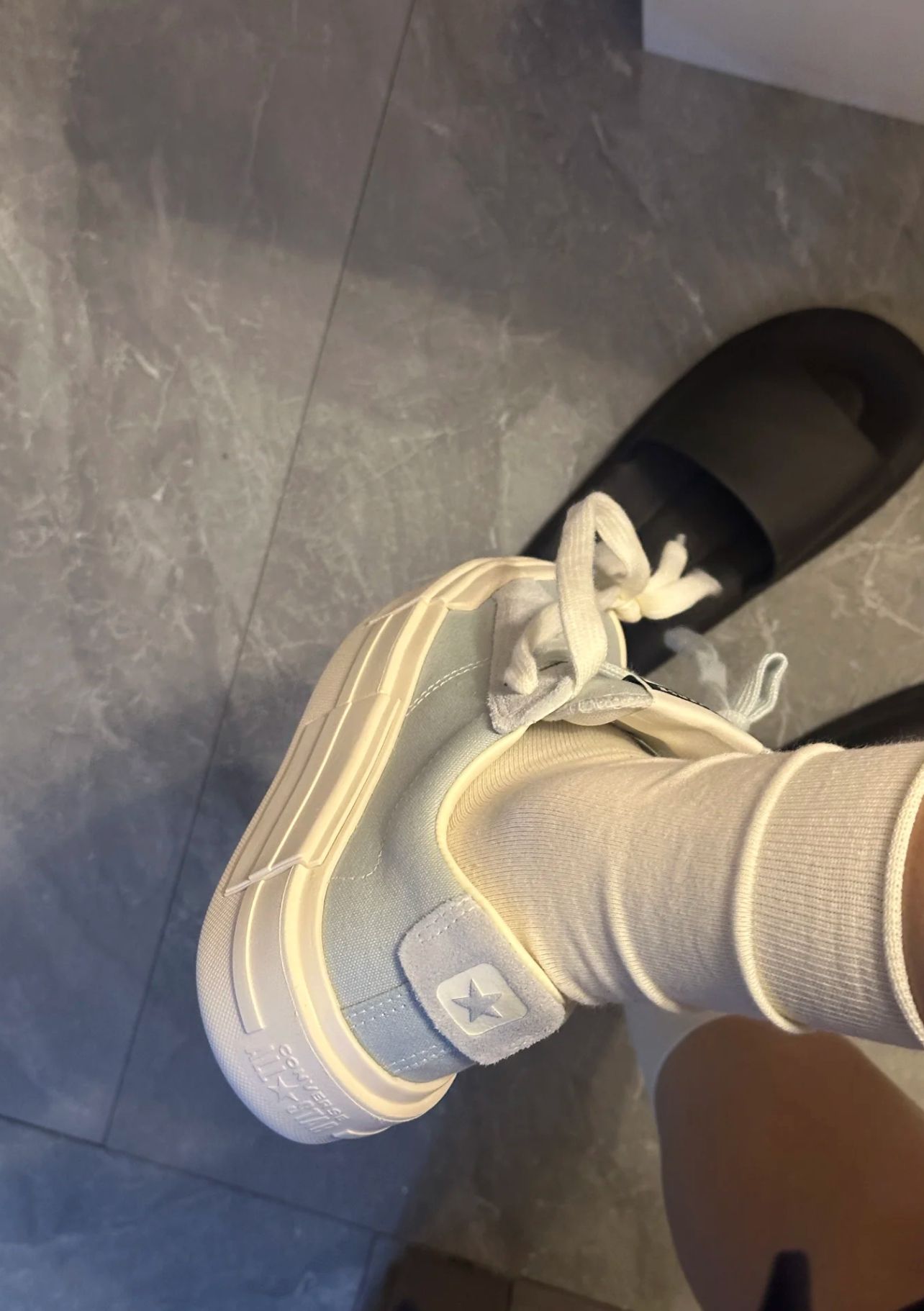 穿着一双白色的鞋子,上面有一颗星。