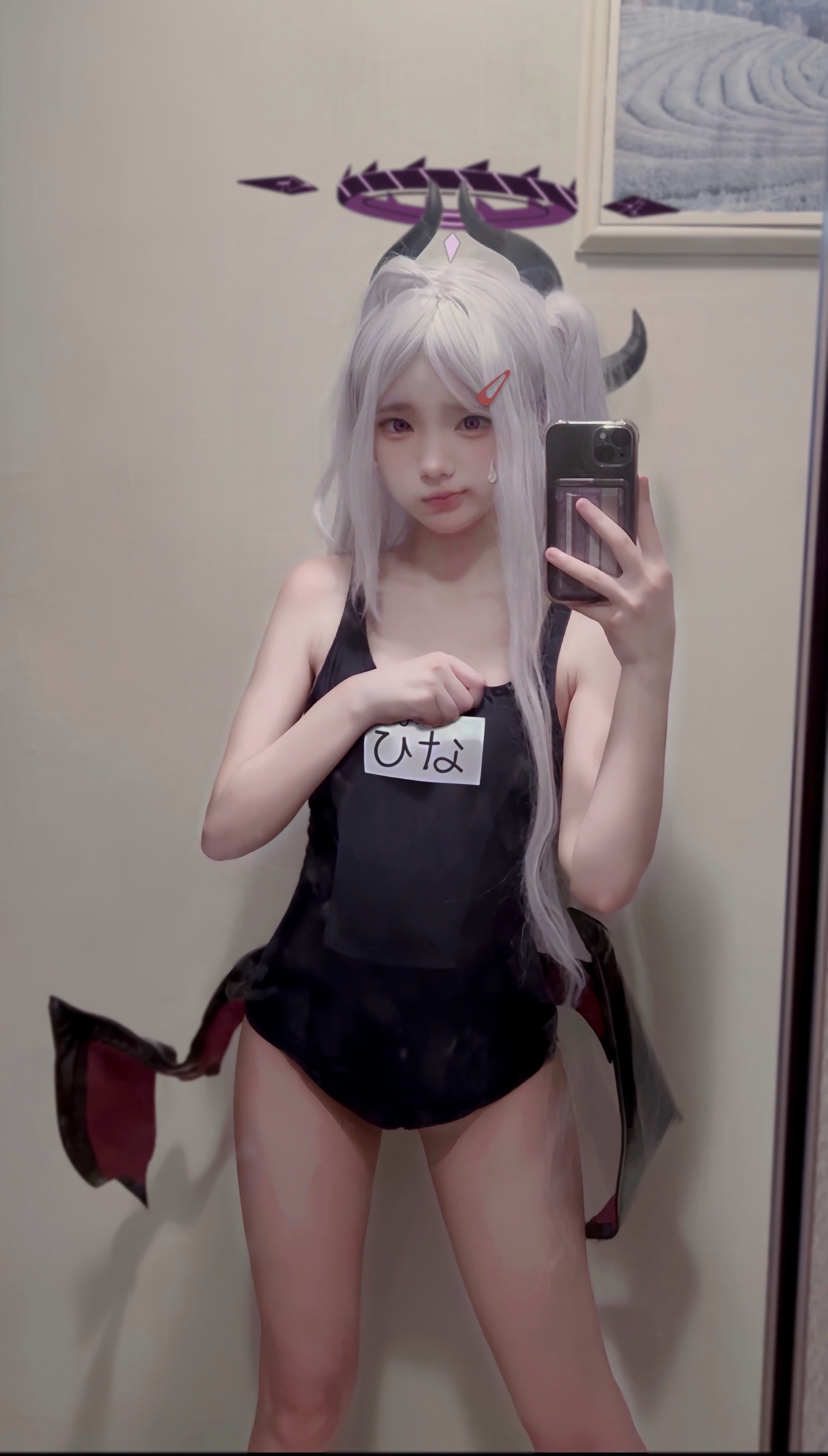 一位穿着黑白泳衣的女孩用手机拍自拍。