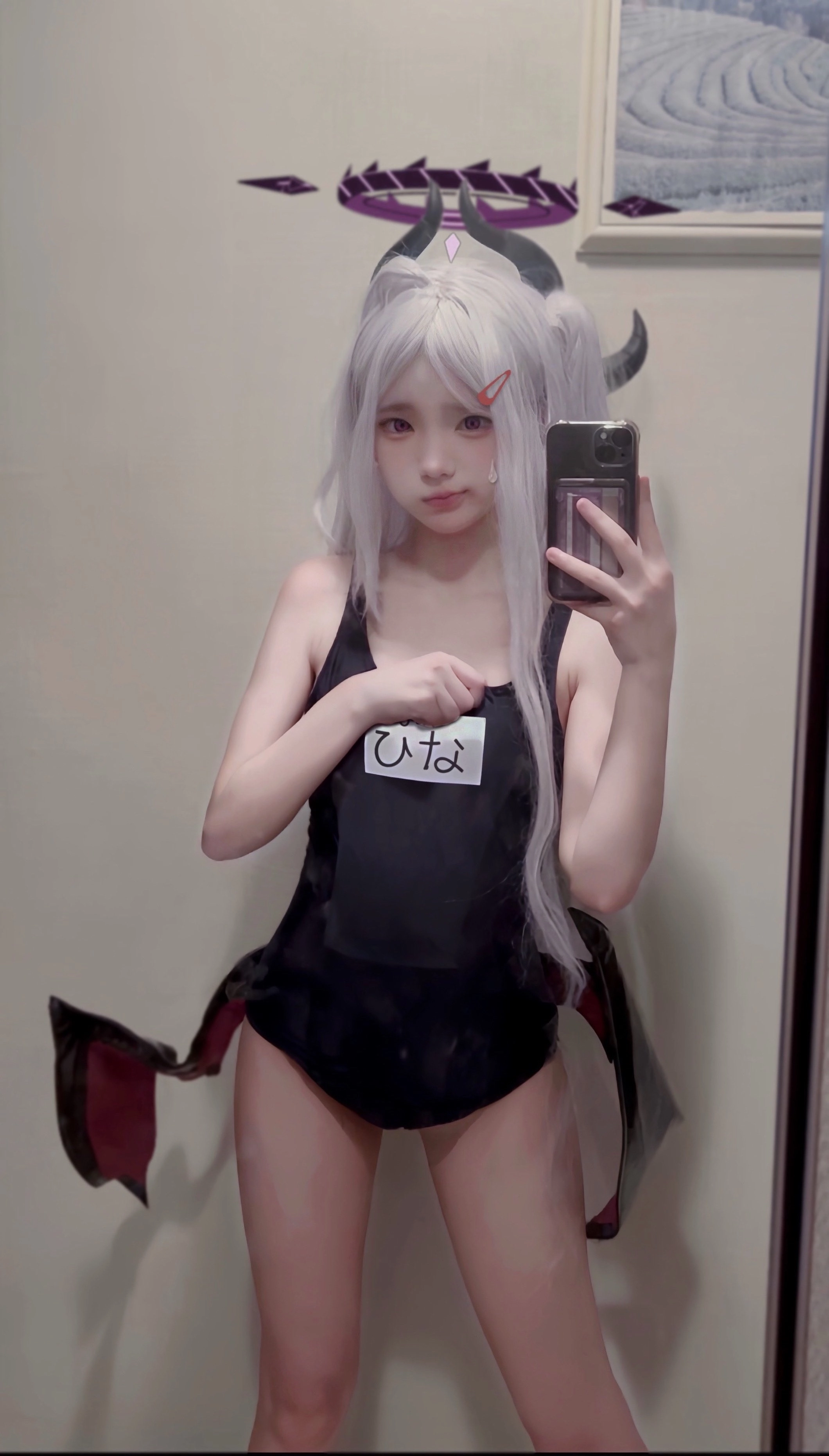 一位穿着黑白泳衣的女孩用手机拍自拍。