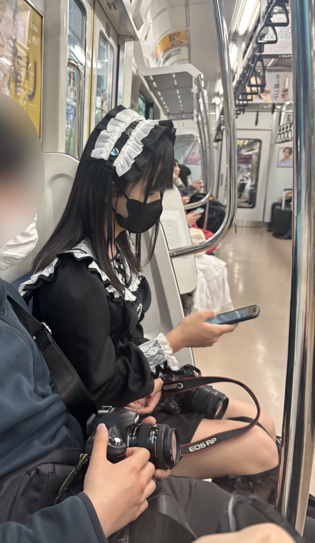 穿着女仆服的女人坐在火车上。