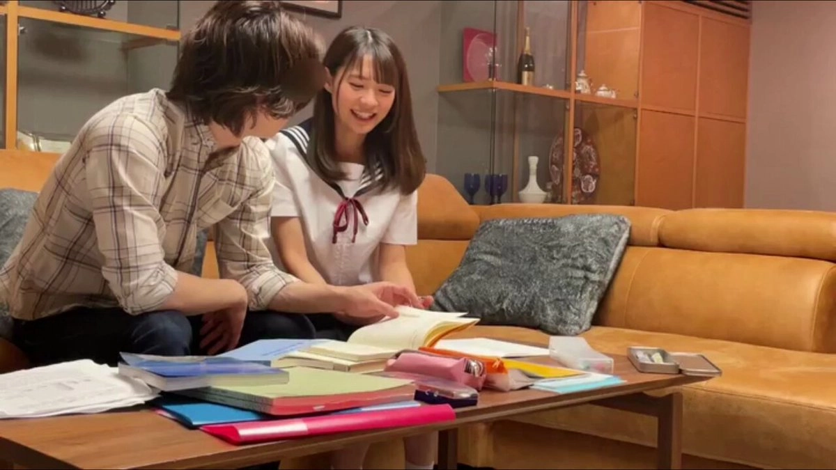 男人和一个女人坐在沙发上,被书籍和杂志包围。