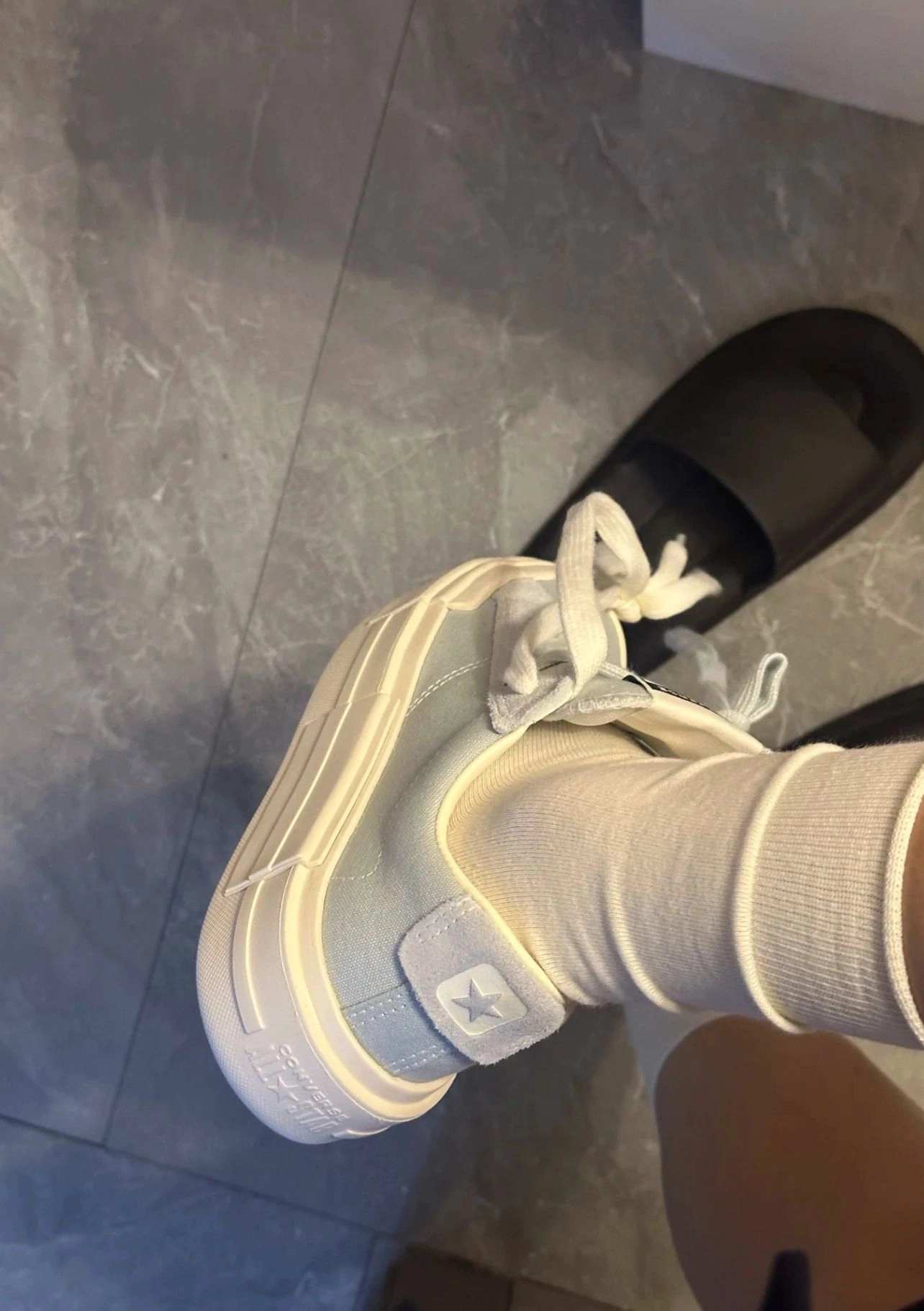 穿着一双白色的鞋子,上面有一颗星。