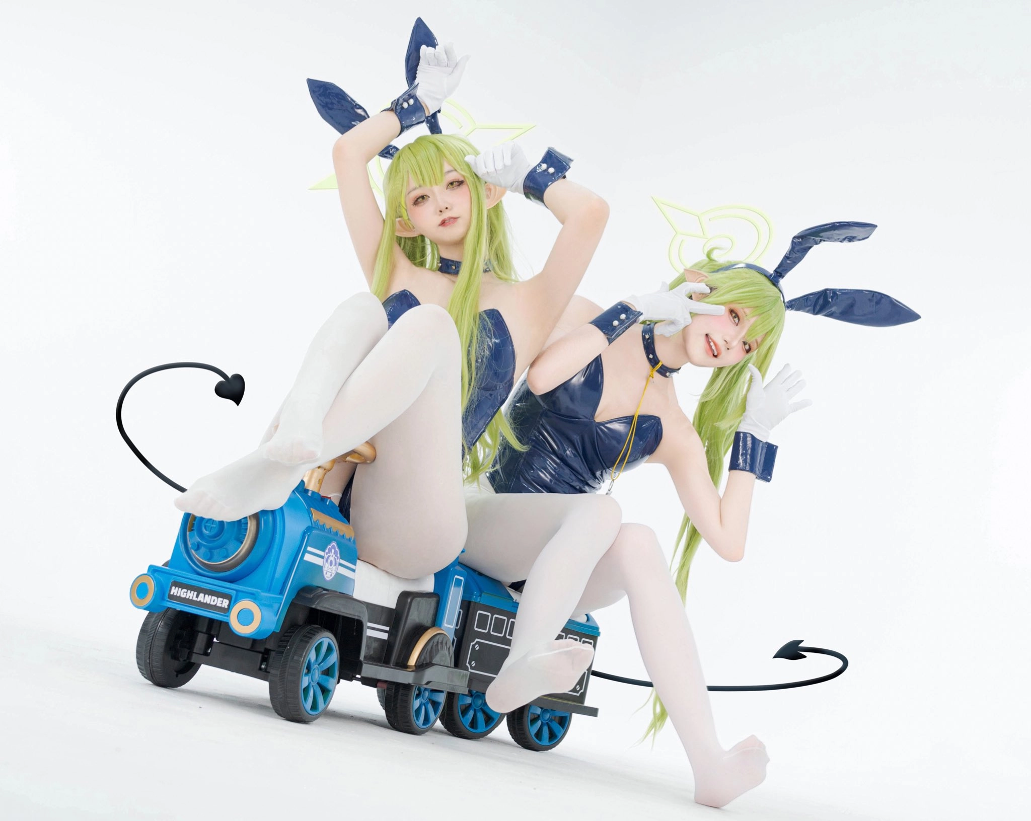 两个女人坐在玩具列车上,在左边,一个在右边。