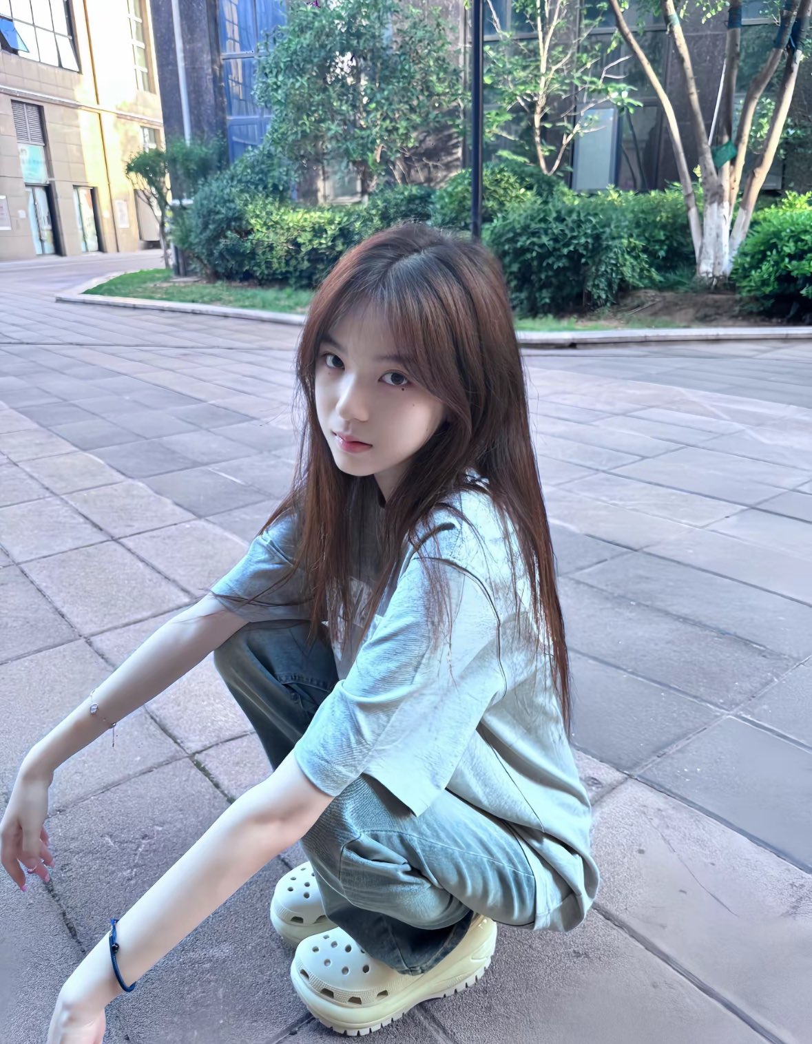 一位穿着蓝色衬衫和牛仔裤的女人坐在地板上。