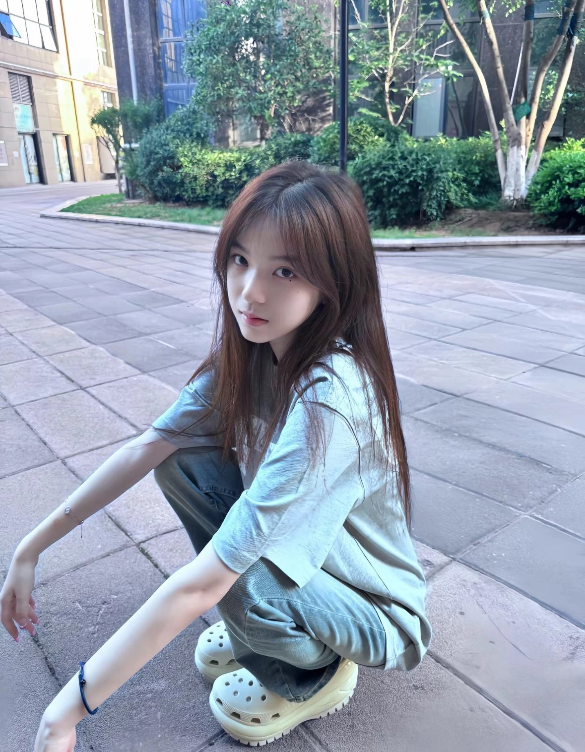 一位穿着蓝色衬衫和牛仔裤的女人坐在地板上。