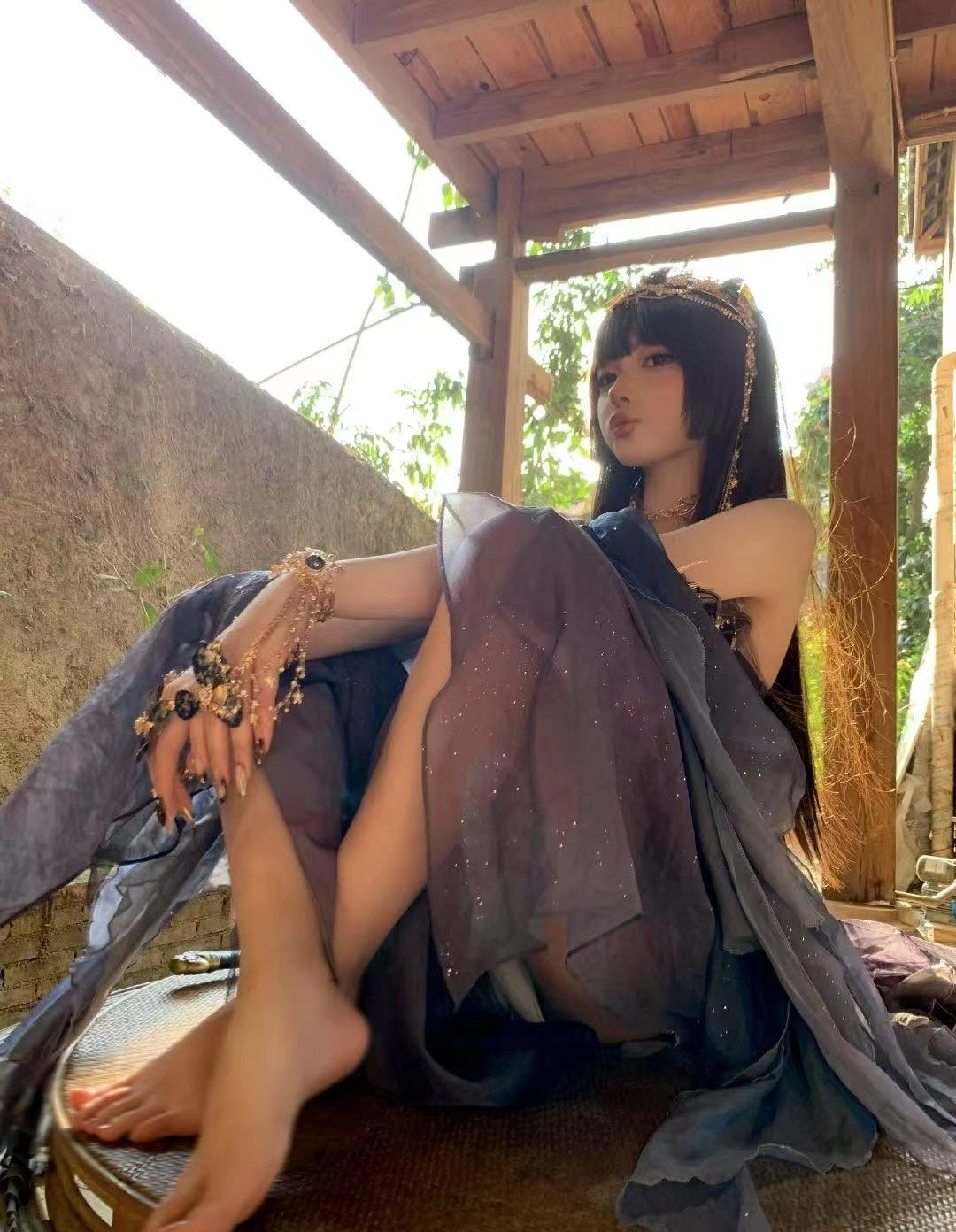 穿着裙子和王冠的女人坐在石头墙上。