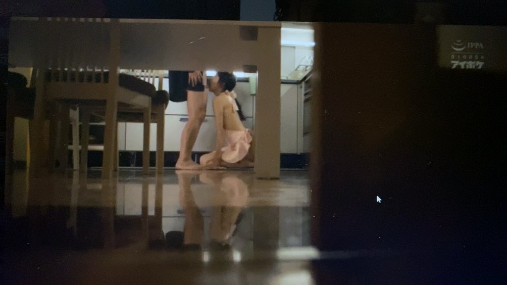 女人跪在一个男人面前,两人都在厨房里。