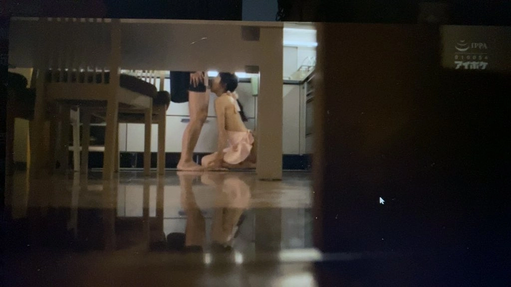 女人跪在一个男人面前,两人都在厨房里。