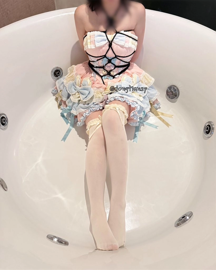 穿着珊瑚的女人坐在浴缸里。