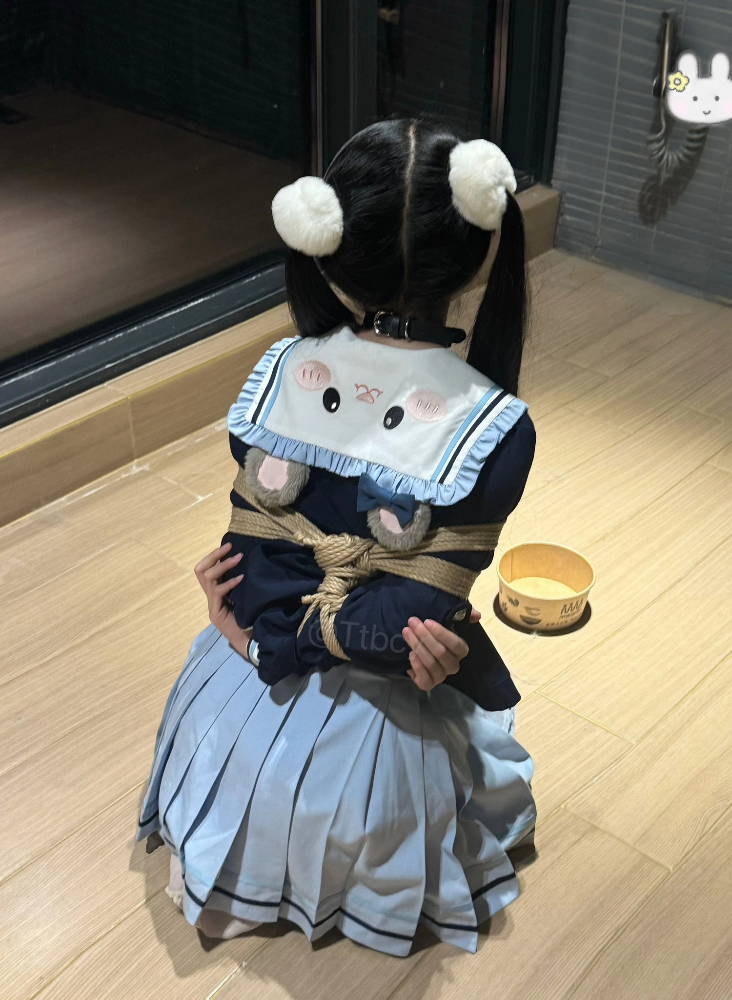 女孩被绑在绳子上,穿着一件Hello Kitty衬衫。